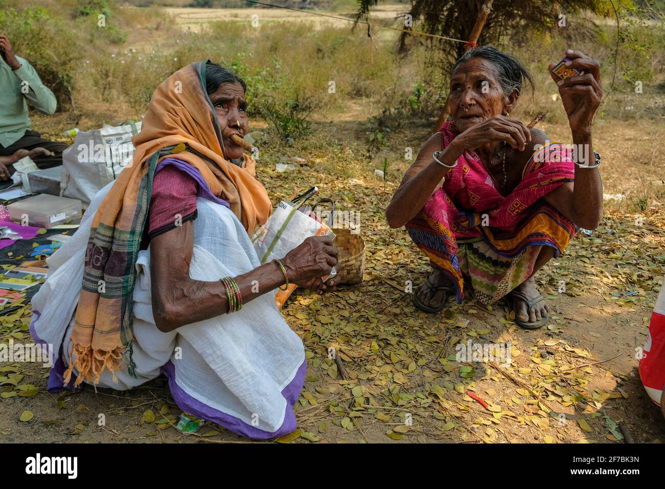 Chatikona, India - February 2021: Adivasi women from the Desia Kondh tribe smoking in the Chatikona market on February 17, 2021 in Odisha, India Stock Photo