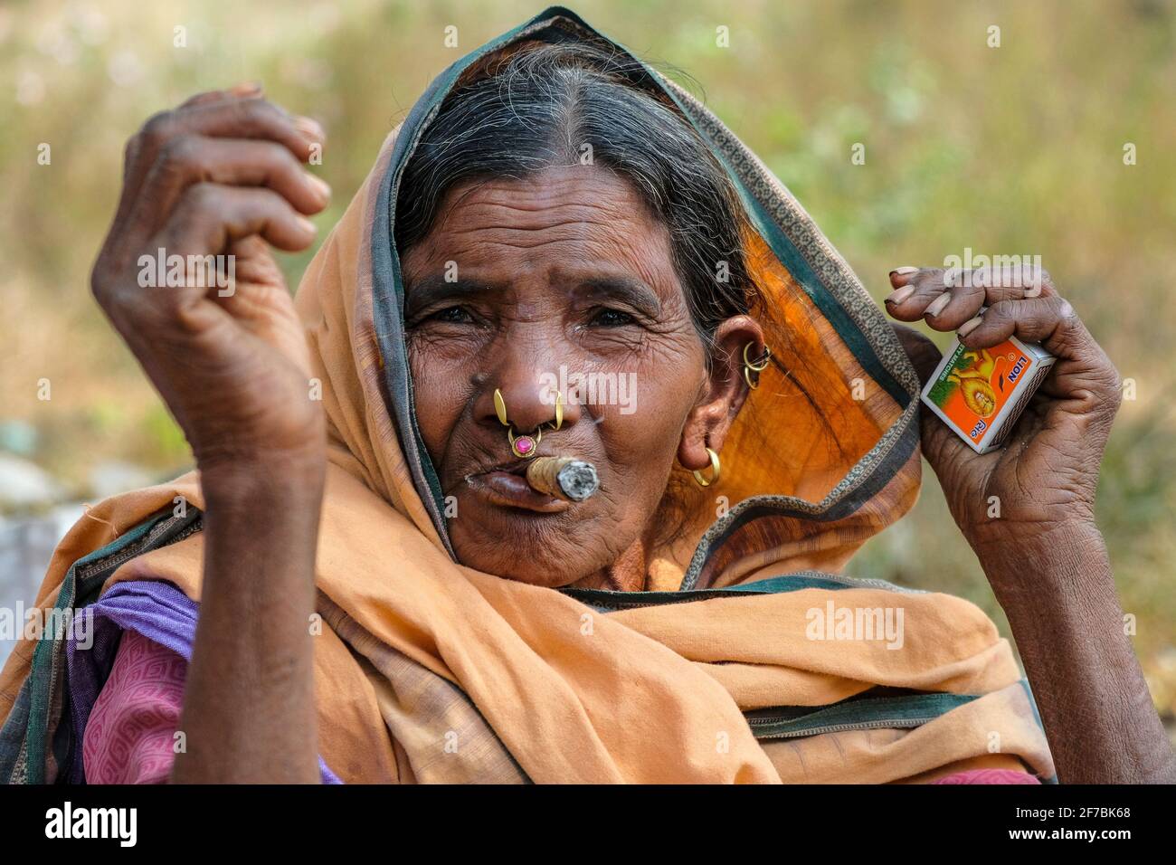 Chatikona, India - February 2021: An Adivasi woman from the Desia Kondh tribe smoking in the Chatikona market on February 17, 2021 in Odisha, India. Stock Photo