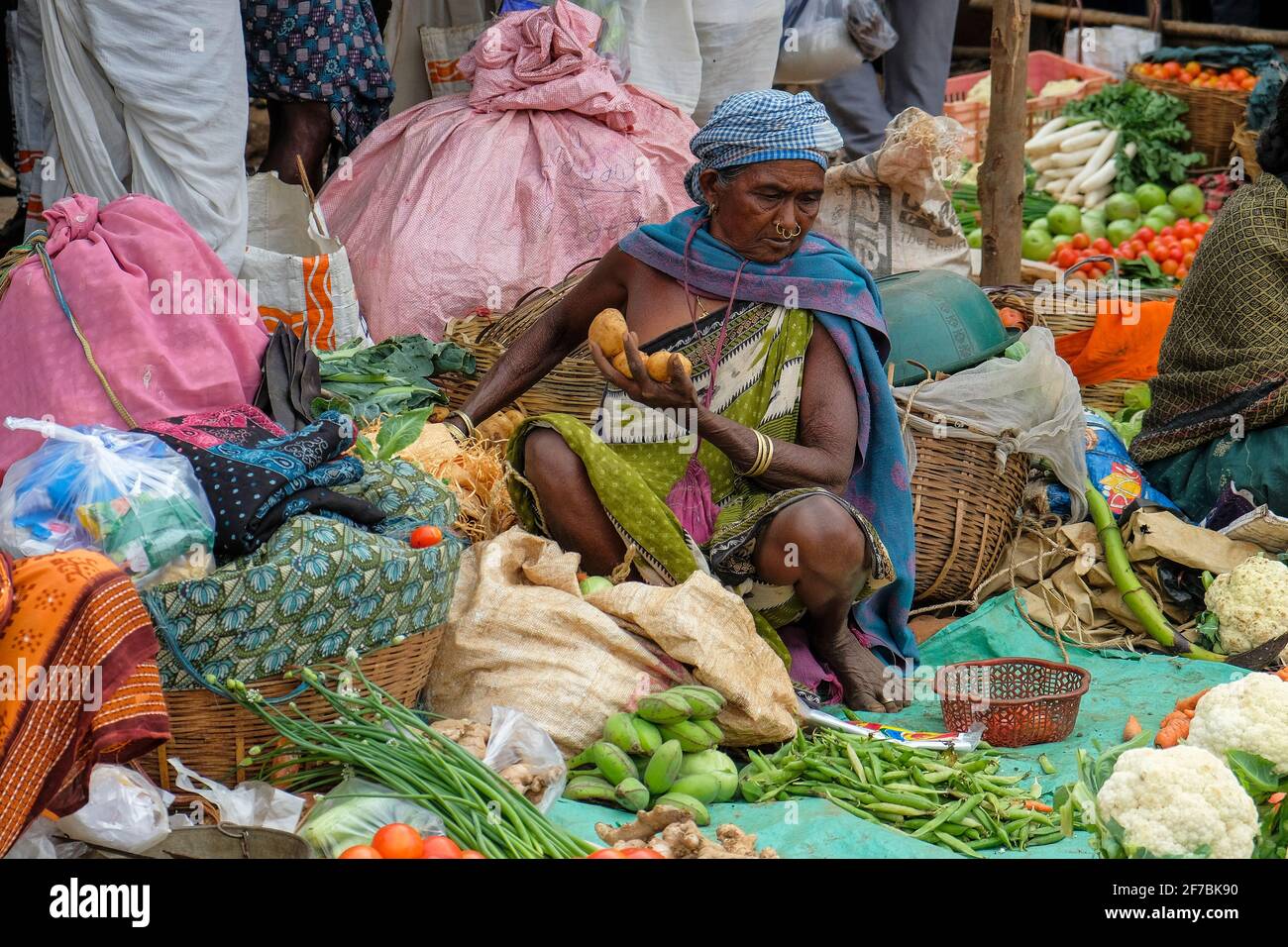 Kunduli, India - February 2021: Adivasi woman from the Desia Kondh tribe selling vegetables in the Kunduli market on February 19, 2021 in Odisha. Stock Photo