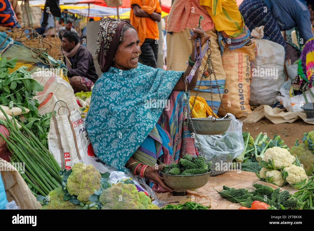 Kunduli, India - February 2021: Adivasi woman from the Mali tribe selling vegetables in the Kunduli market on February 19, 2021 in Odisha, India. Stock Photo