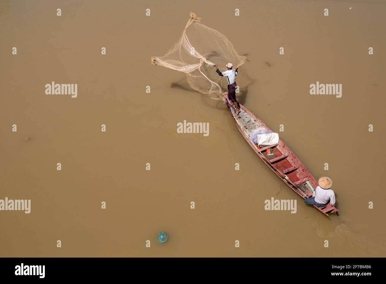 A fisherman casts his nets in the water of the Bago River, Bago, Myanmar Stock Photo