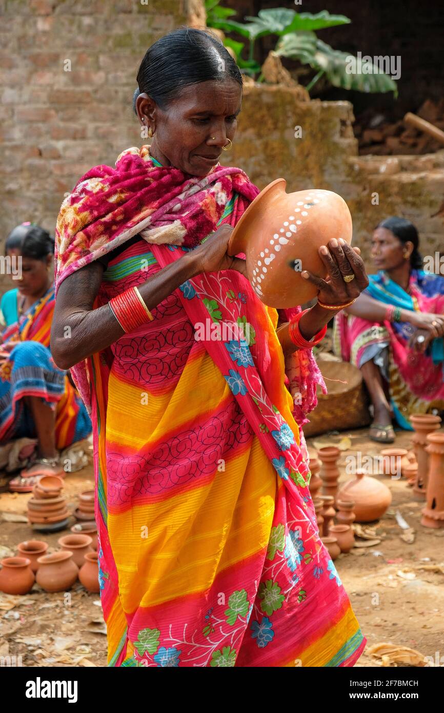 Kunduli, India - February 2021: Adivasi woman from the Kondh tribe shopping for clay vases in the Kunduli market on February 19, 2021 in Odisha, India Stock Photo