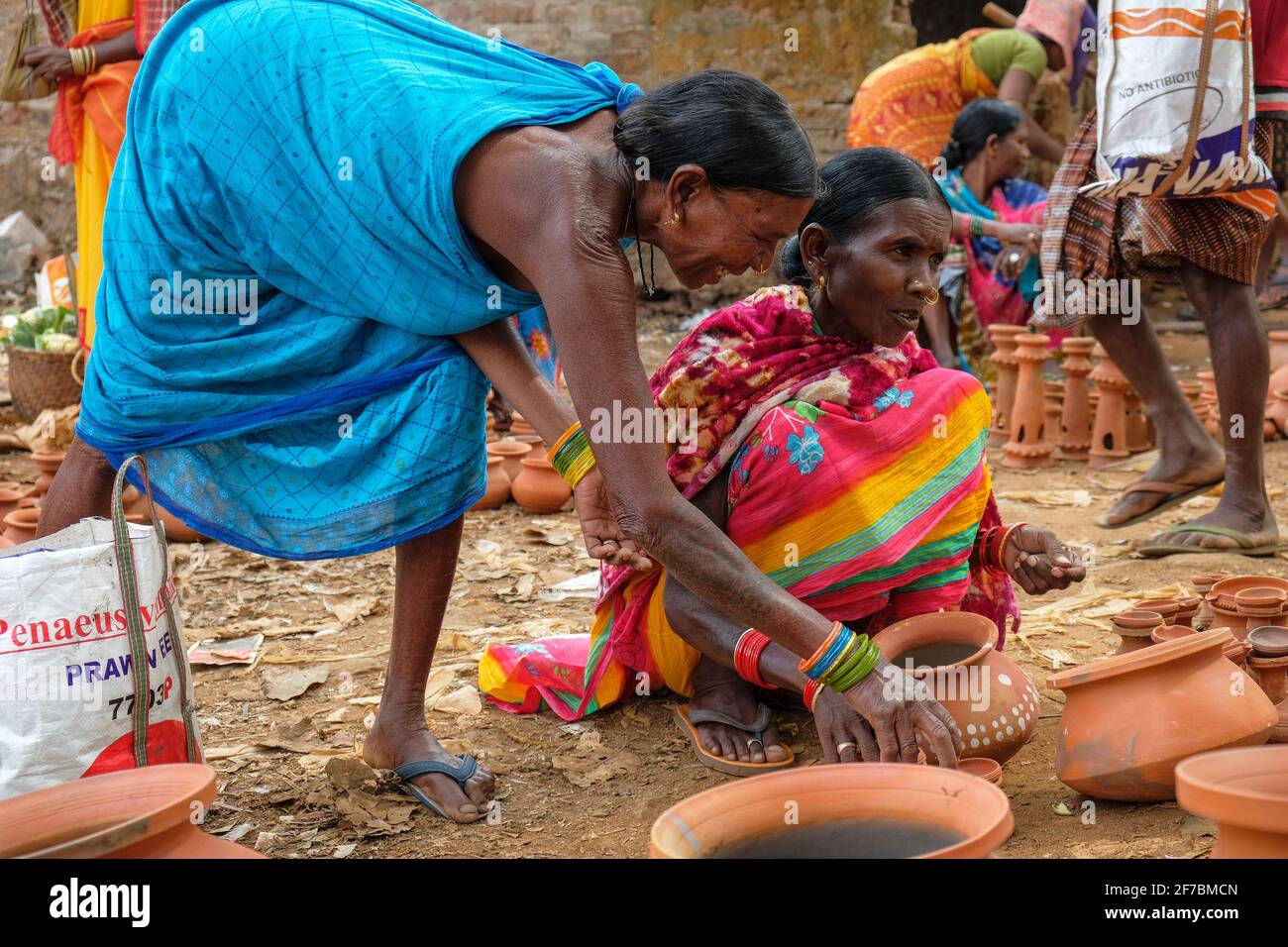 Kunduli, India - February 2021: Adivasi women from the Kondh tribe shopping for clay vases in the Kunduli market on February 19, 2021 in Odisha, India Stock Photo