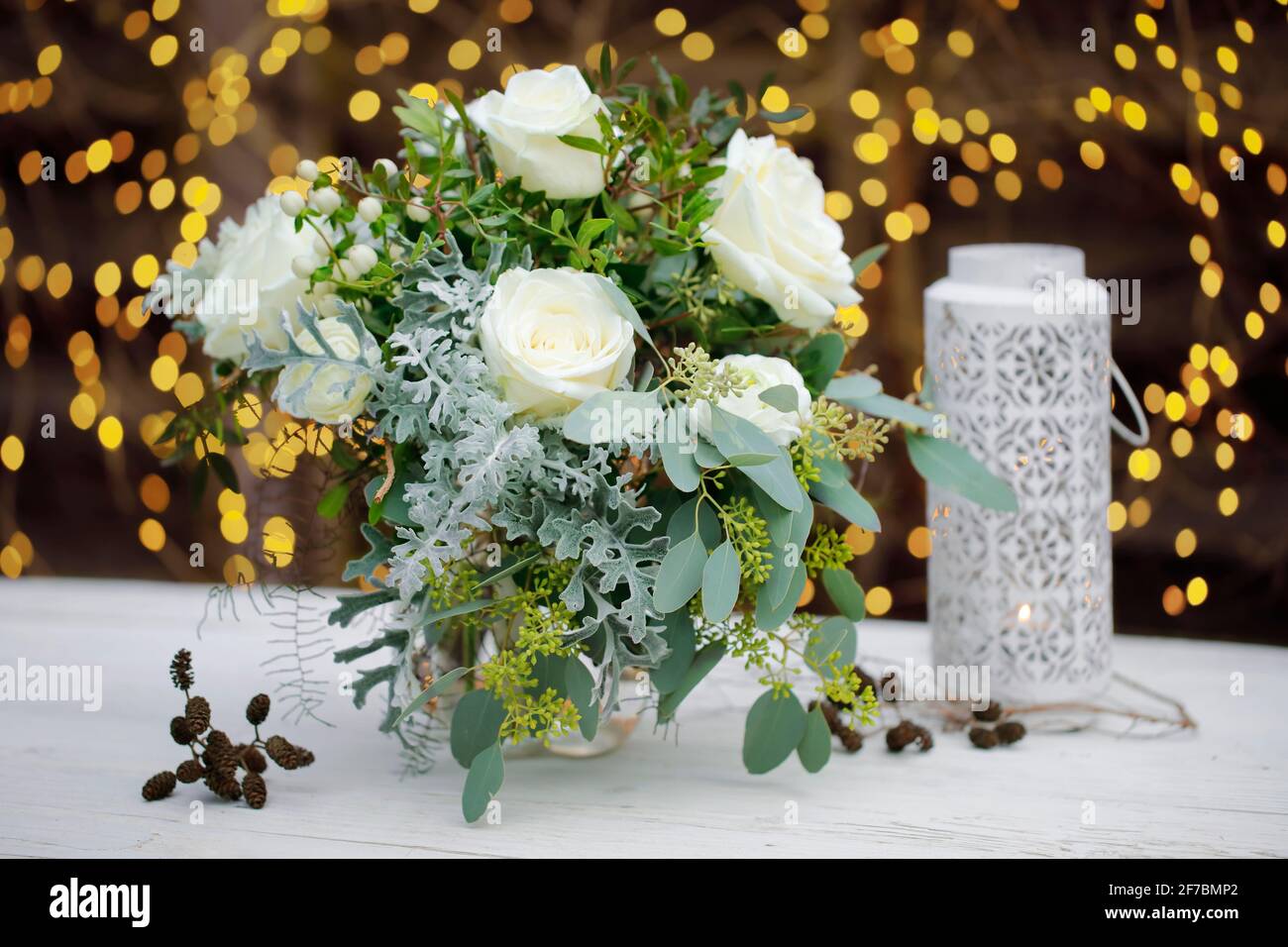 flower bouquet on wood in front of fairy lights Stock Photo