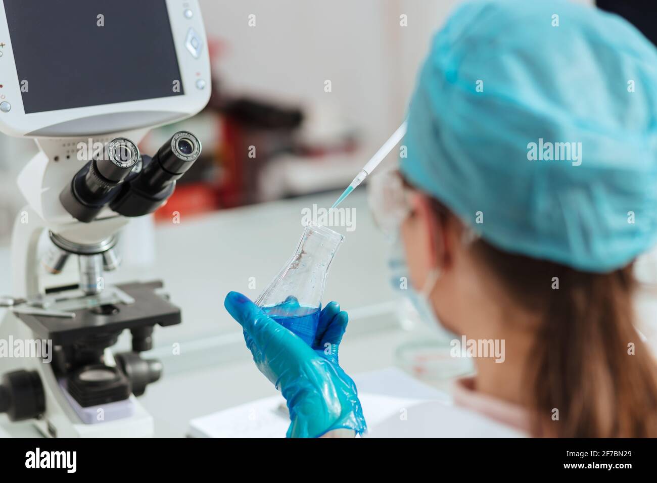 close up. female laboratory assistant testing liquid in a laboratory ...