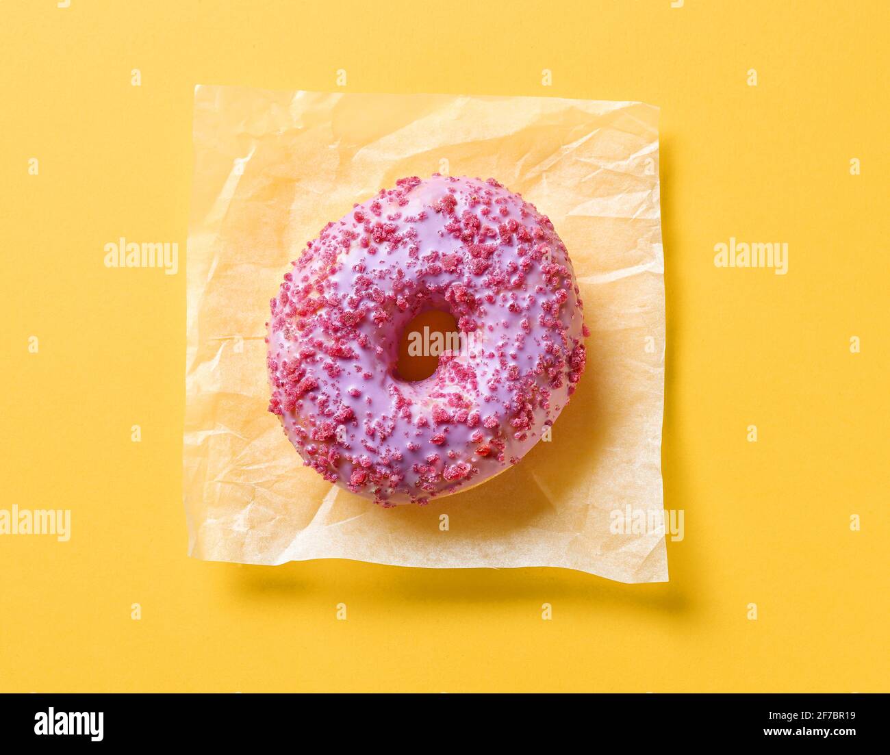 pink donut on yellow paper background, top view Stock Photo - Alamy