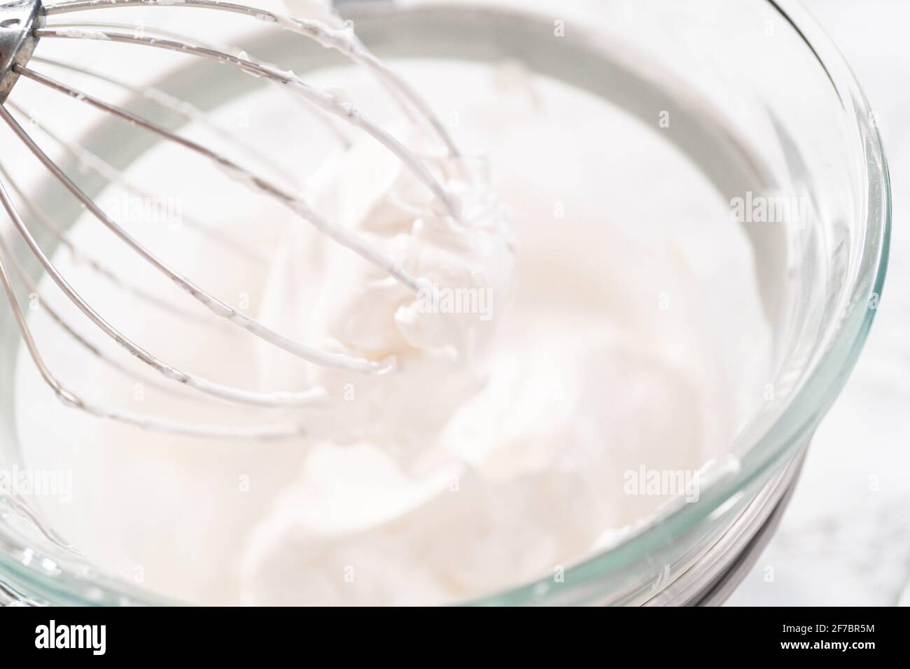 Making meringue in kitchen mixer to bake unicorn meringue cookies Stock