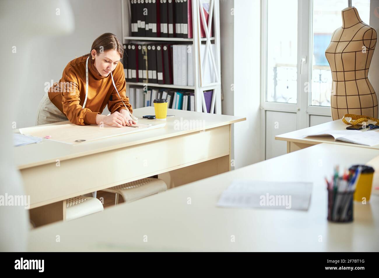 Lonely woman near table laying out her sketch on paper Stock Photo