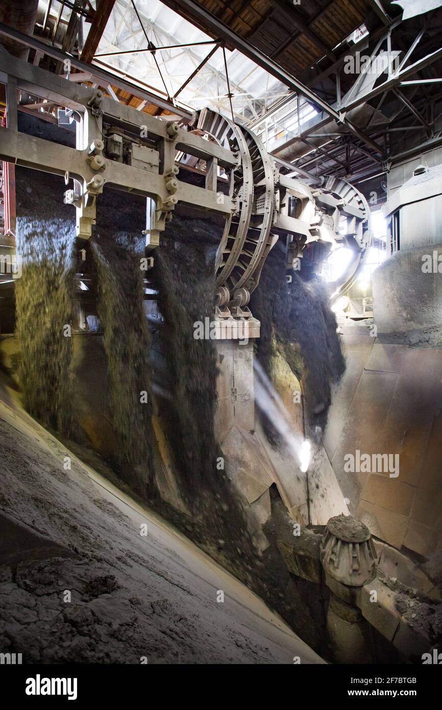 Stepnogorsk, Kazakhstan - April 19, 2012: Railway car dumper quick unload system. Mining and processing plant. Rotary tippler. Ore is motion-blurred Stock Photo