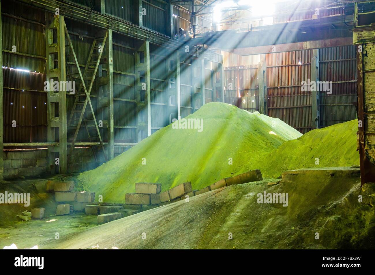 Heap of yellow dry sulphur on factory warehouse. Sulfuric acid production. Stock Photo