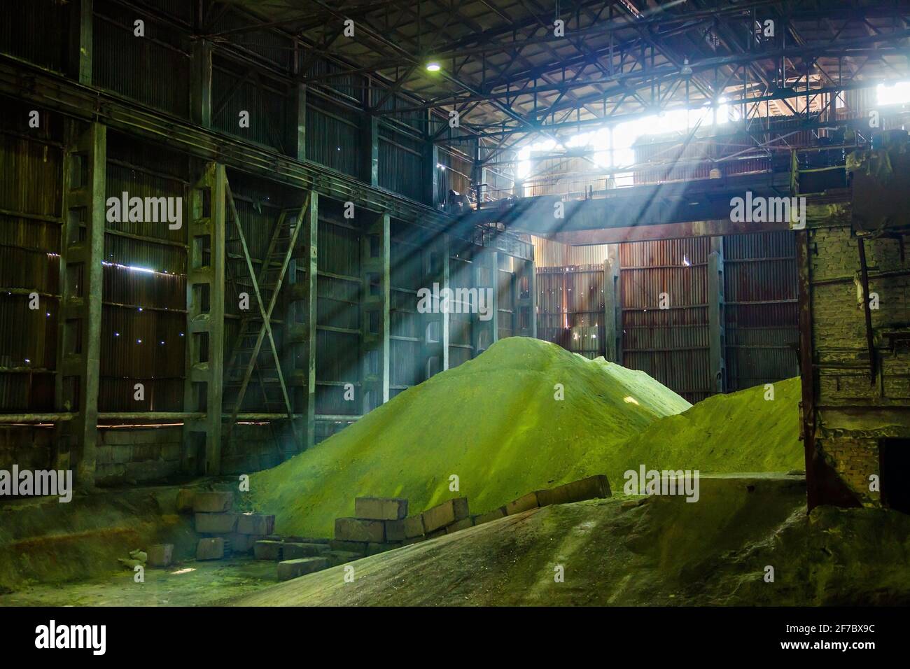 Heap of yellow dry sulfur on factory warehouse. Sulphuric acid production. Stock Photo