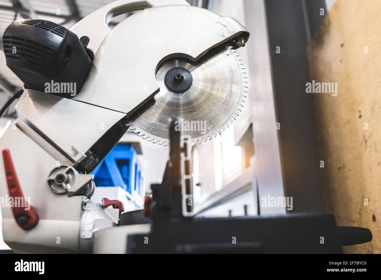 Carpenter cutting flaxboard using sliding compound mitre saw Stock Photo