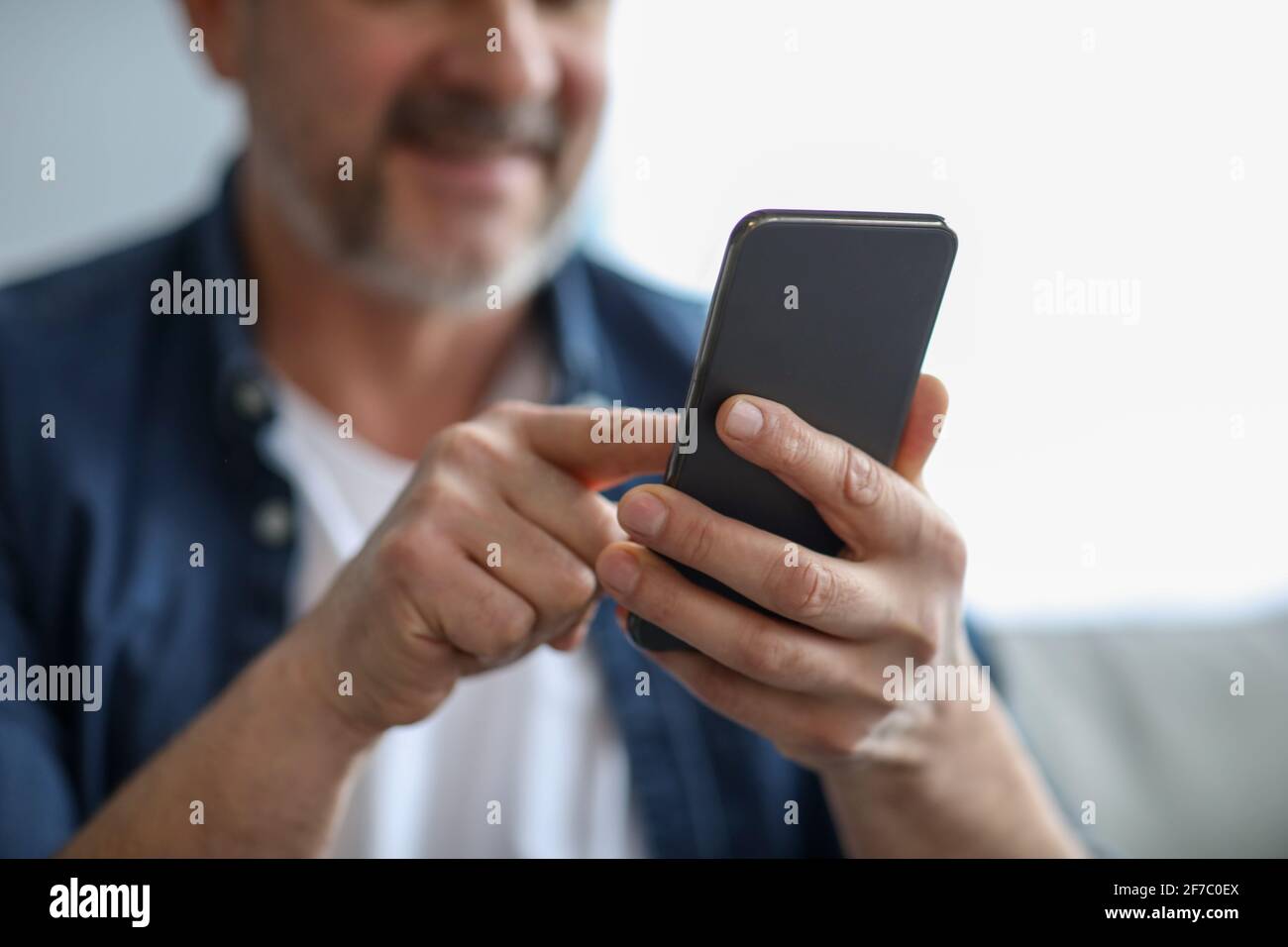 Unrecognizable matured man using modern mobile phone Stock Photo