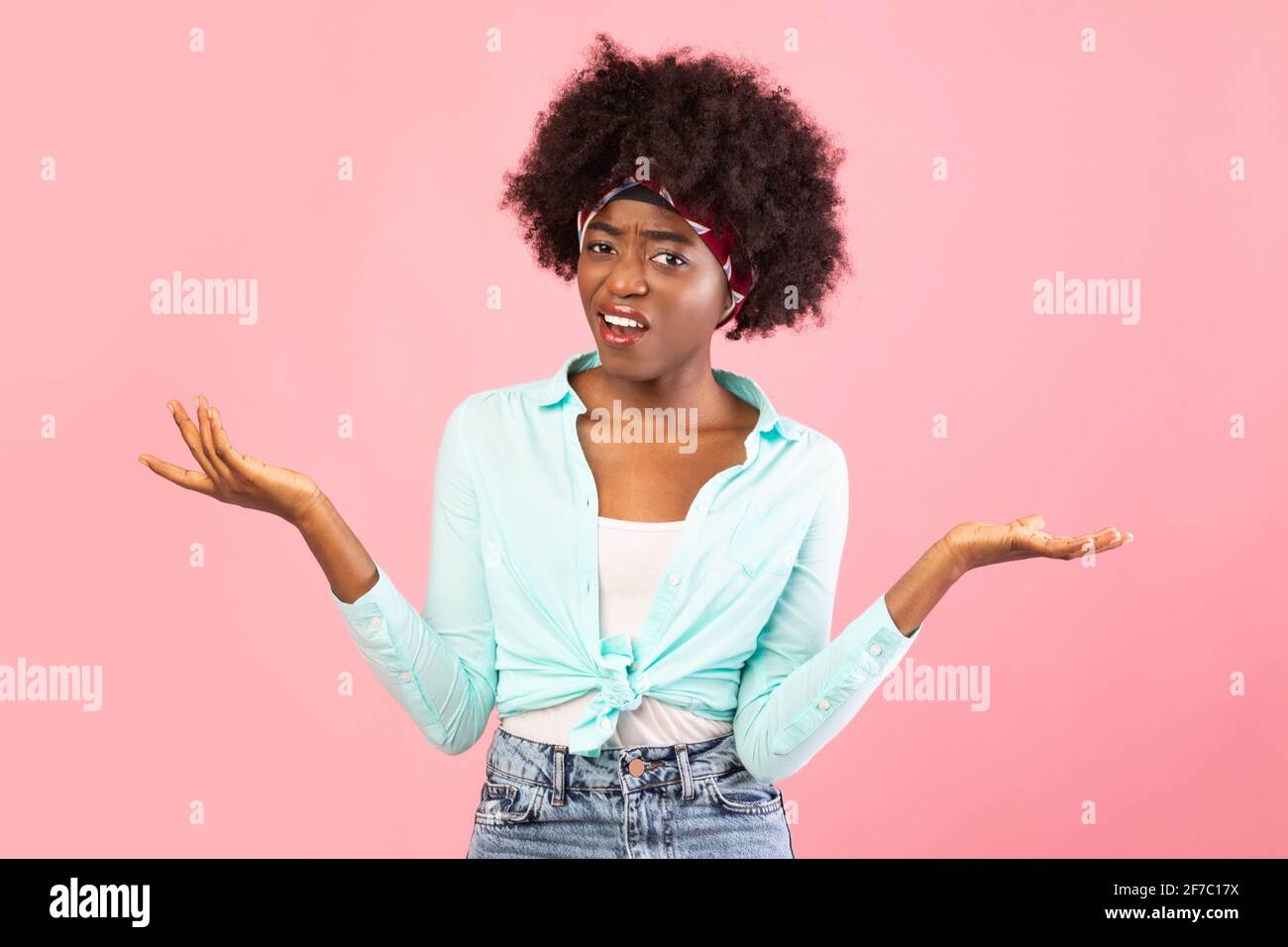 Discontented Black Young Woman Shrugging Shoulders Standing Over Pink Background Stock Photo