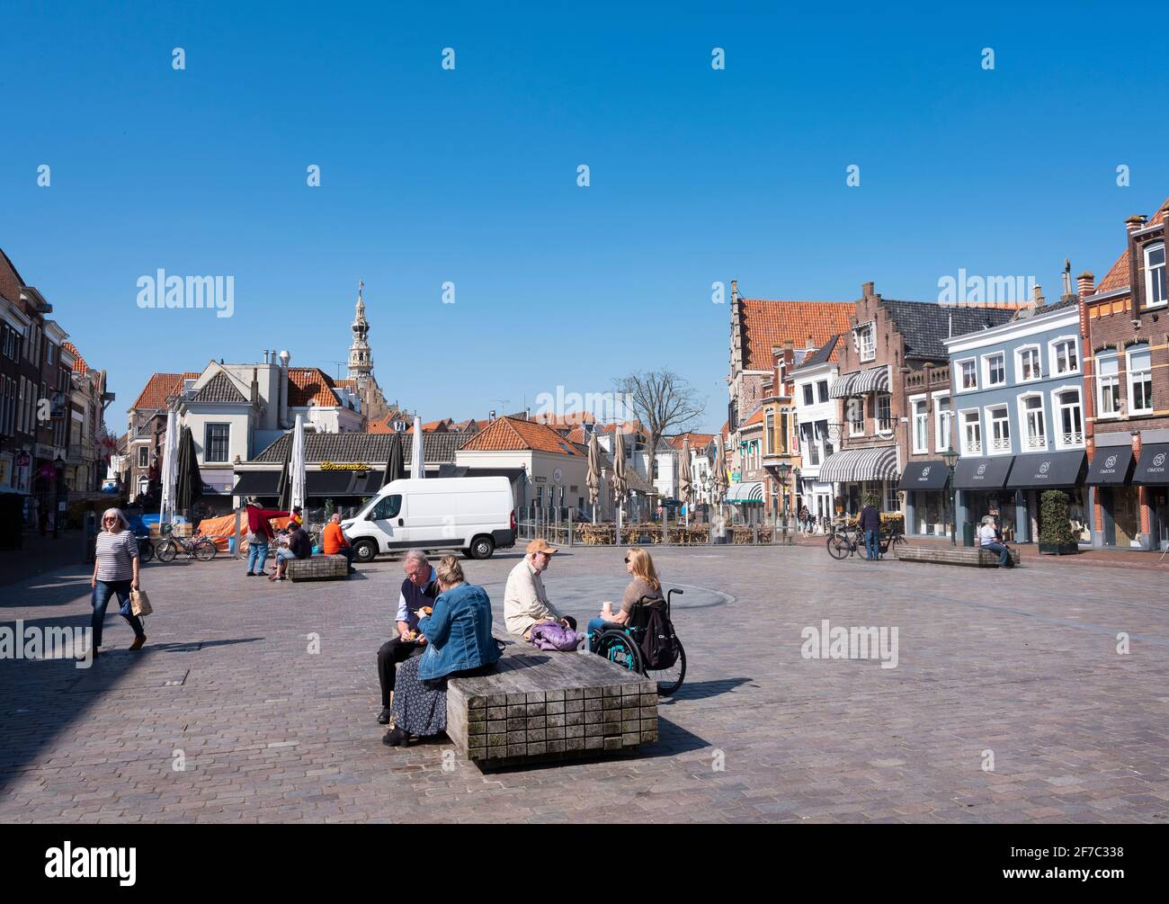 people enjoy sunshine on old square in dutch town of zierikzee in spring Stock Photo