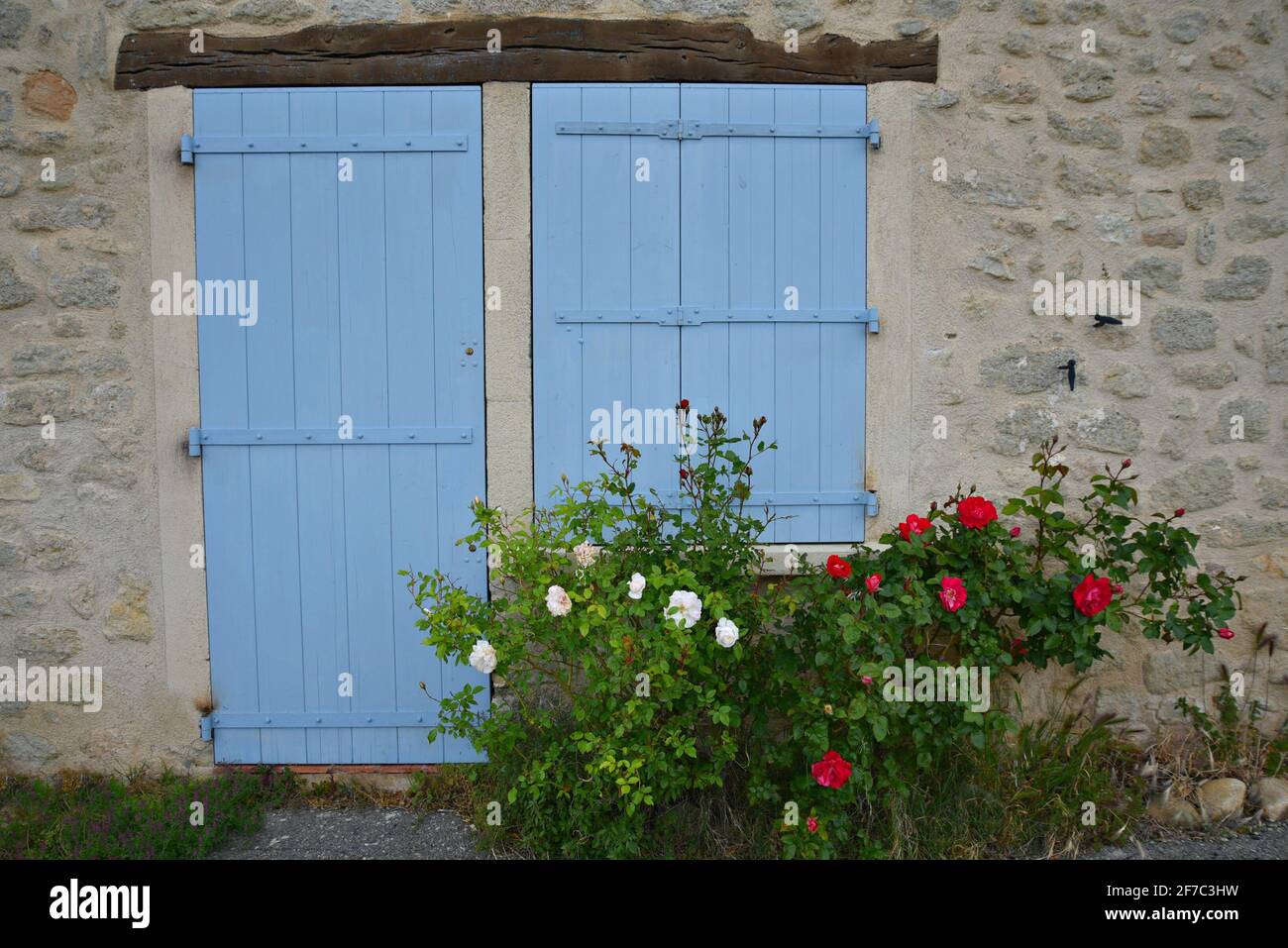 Rural Provençal style house stone facade with light blue shutters in the picturesque village of Grambois, Provence-Alpes-Côte d'Azur, Vaucluse, France Stock Photo