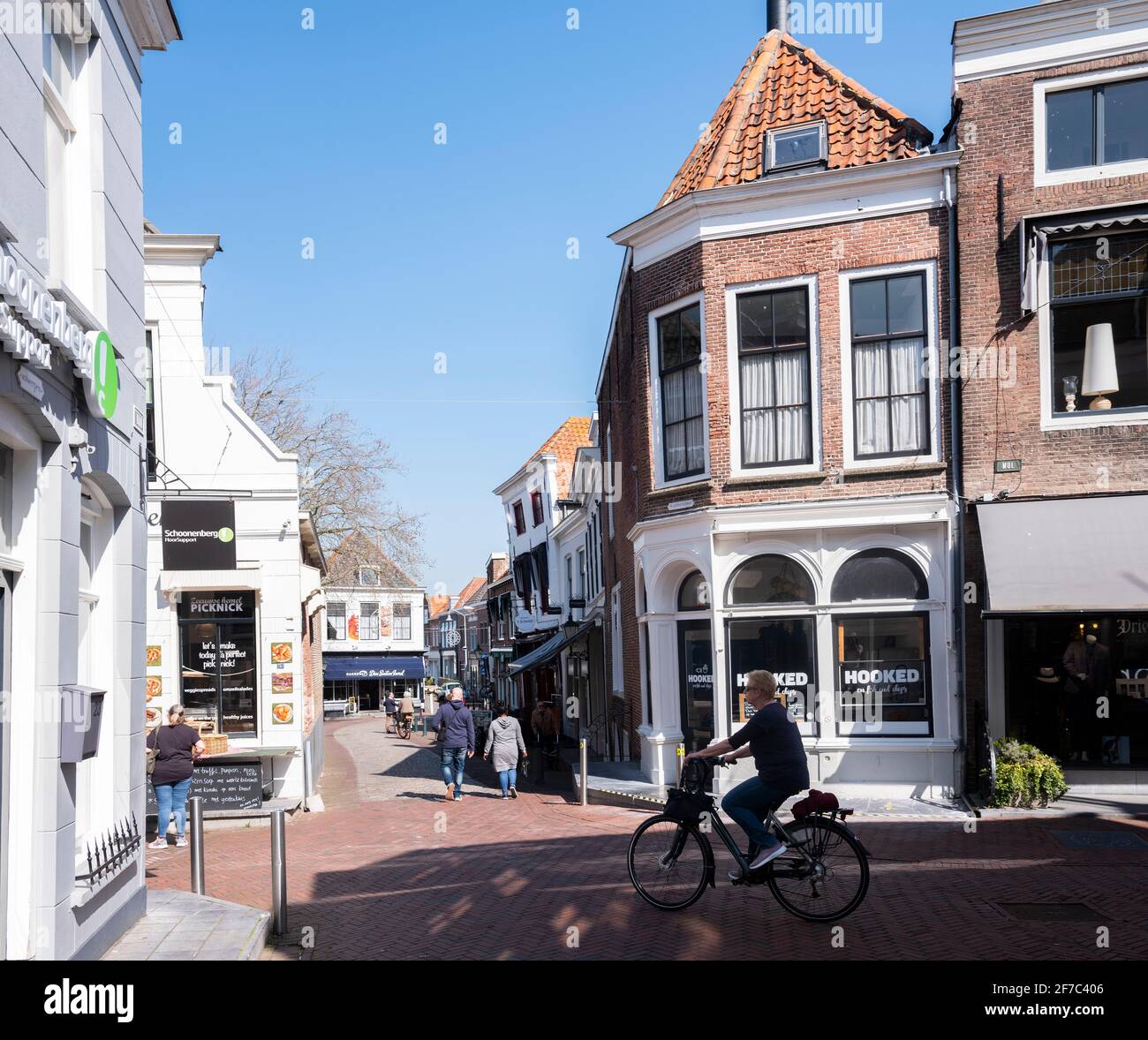 people enjoy sunshine on old street in dutch town of zierikzee in spring Stock Photo