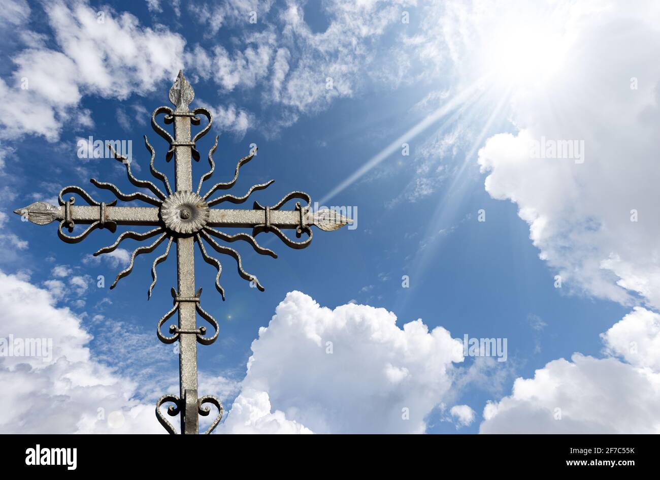 Closeup of a wrought iron religious cross on beautiful blue sky with