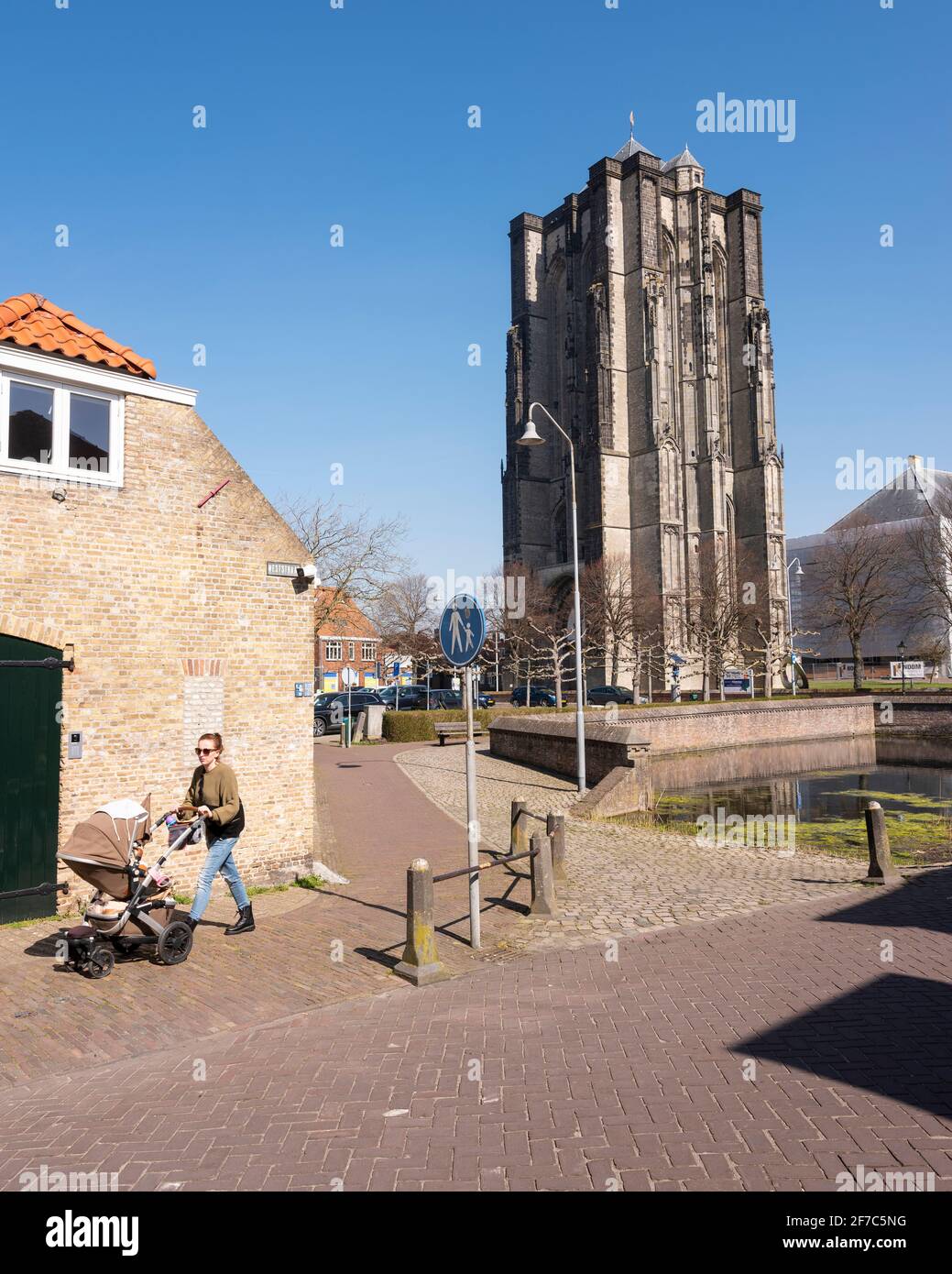 young woman with pram near old tower in old city of zierikzee Stock Photo