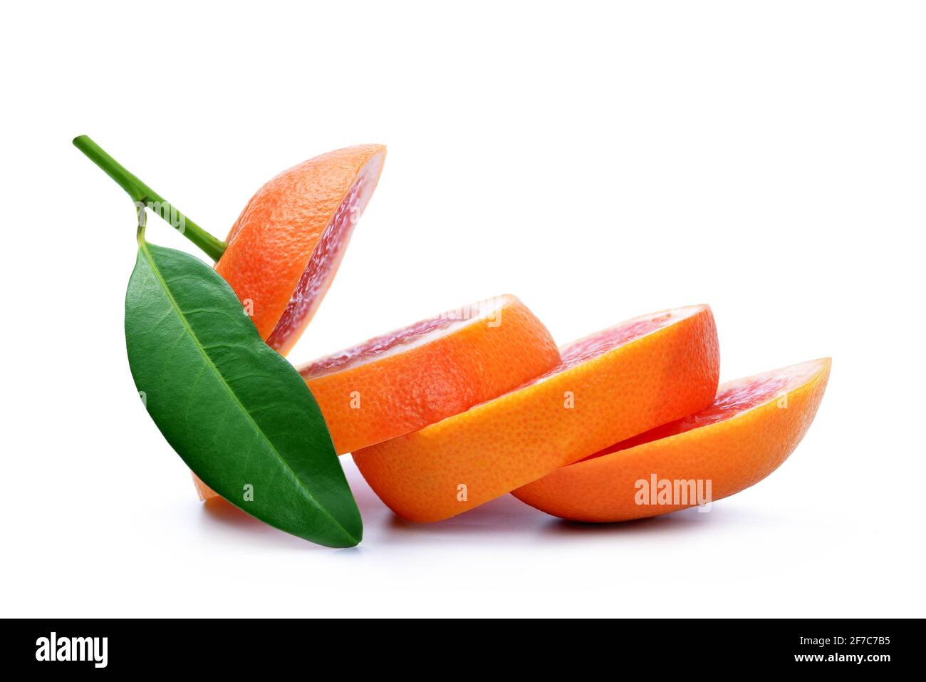Sliced grapefruit with green leaf isolated on white background. Stock Photo