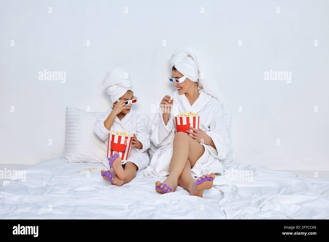 woman with daughter in white bathrobes watching movie Stock Photo Alamy