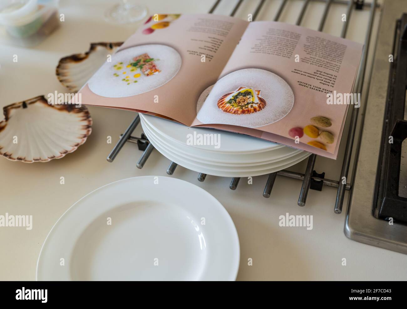 Fine dining tasting menu do-it-yourself at home instructions by chef Paul Wedgwood on kitchen counter with plates and scallop shells Stock Photo
