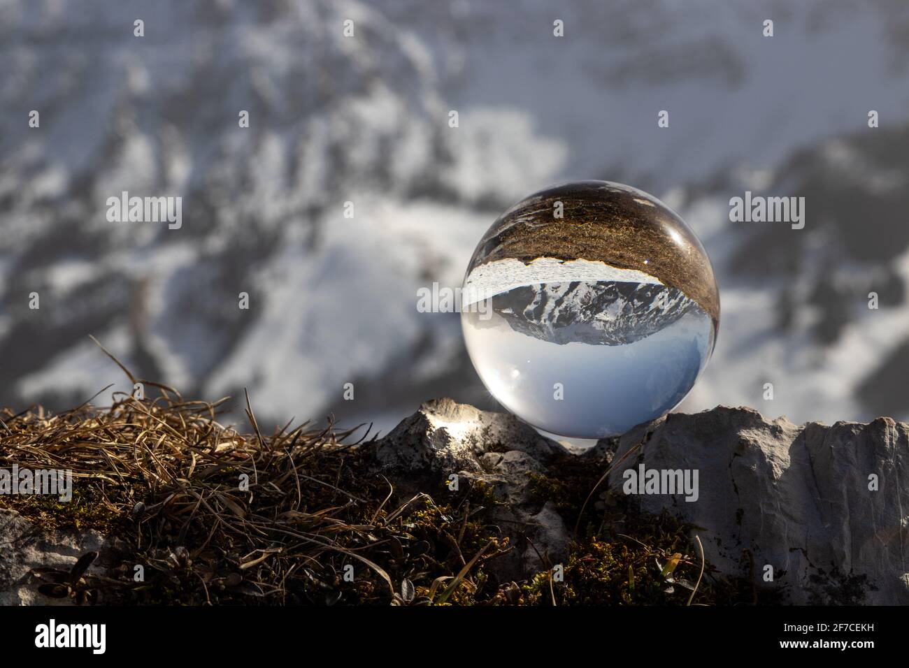 Sunny weather in the snowy mountains through a lens ball Stock Photo