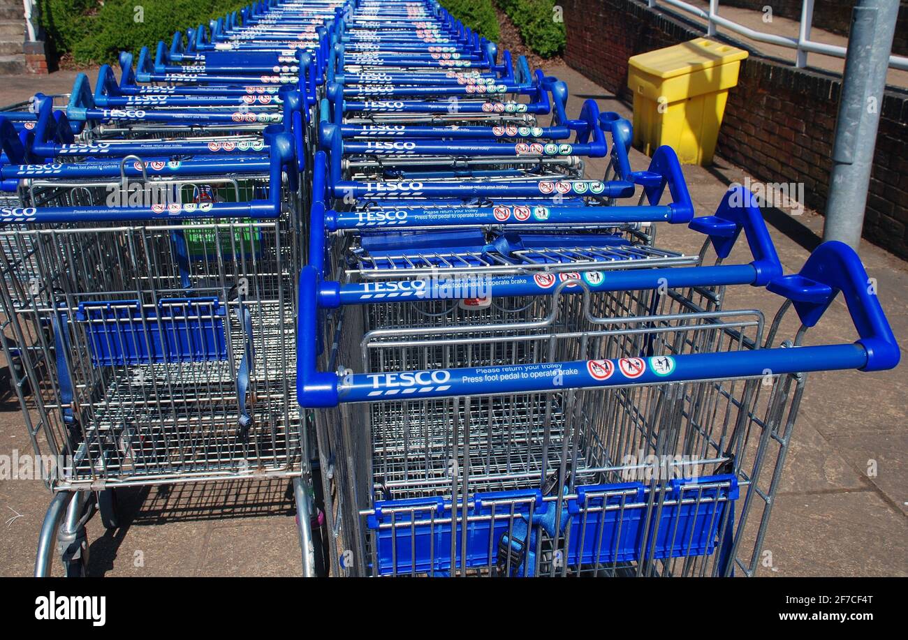 Rows of shopping trolleys outside a branch of Tesco supermarket at Tenterden in Kent, England on April 4, 2021. Stock Photo