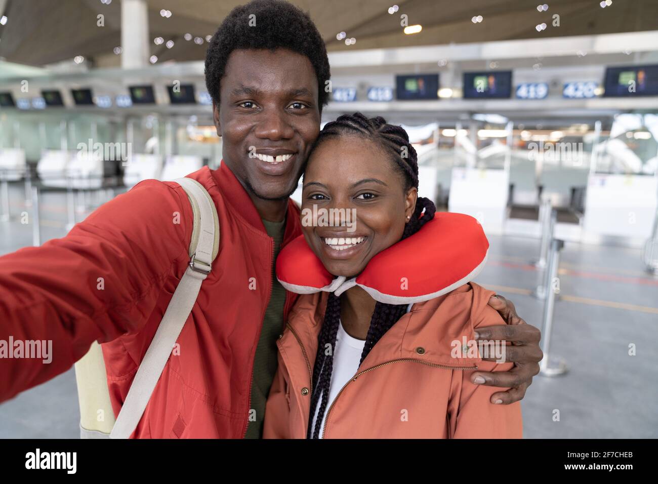 Happy African American couple taking selfie at airport terminal, ready for travel. Back to normality Stock Photo