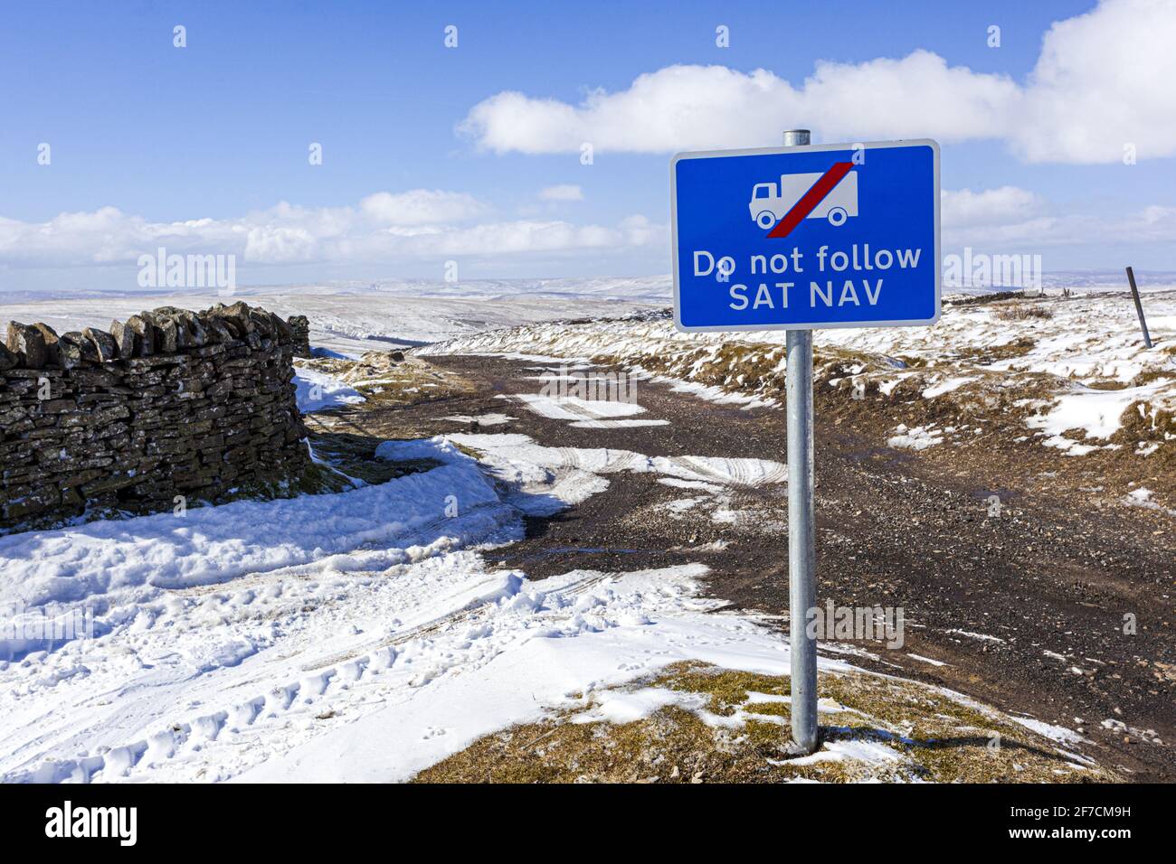 The Pennines in winter - A Do Not Follow Sat Nav sign for lorries on a track in a snowy landscape near Nenthead, Cumbria UK Stock Photo