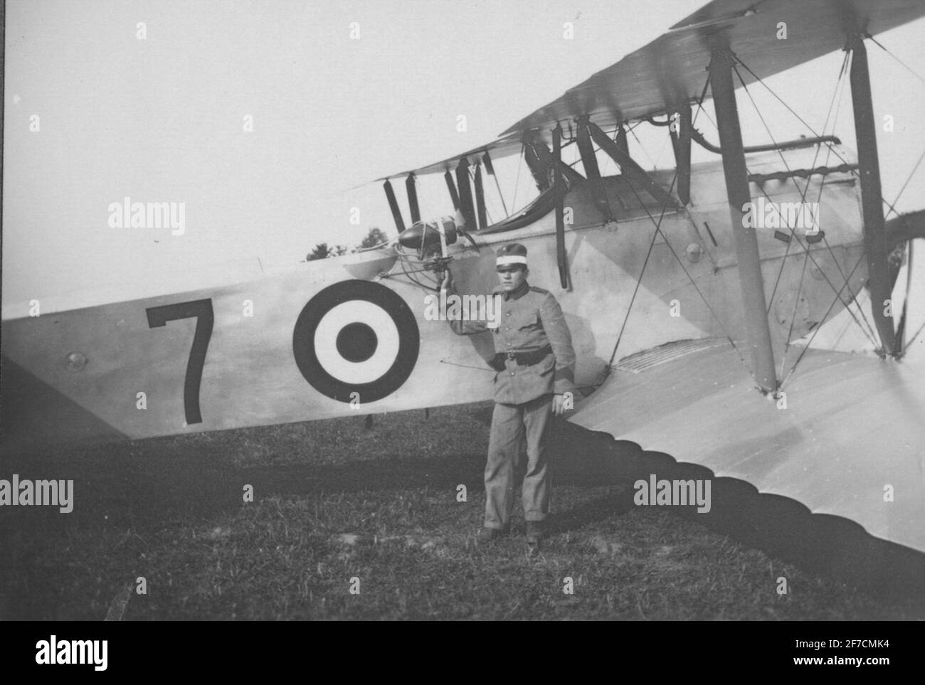 Man at a military propeller aircraft on an airfield. Portrait of
