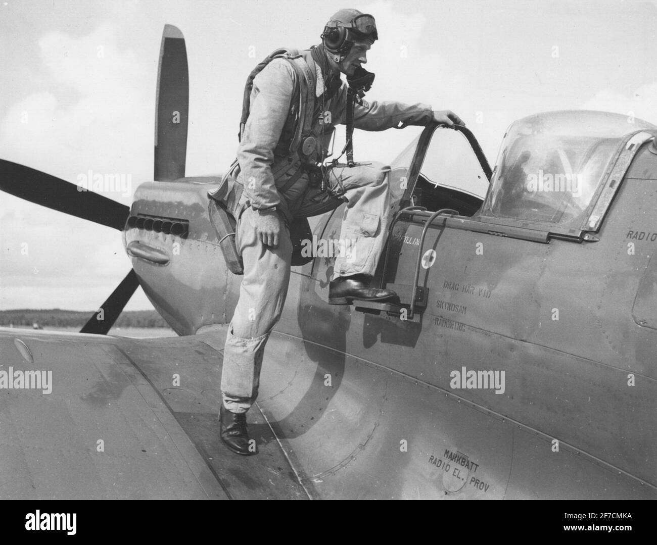 A man dressed in the aircraft suit stepping into aircraft's 31 Spitfire.  A man dressed in the aircraft suit stepping into aircraft's 31 Spitfire. Stock Photo