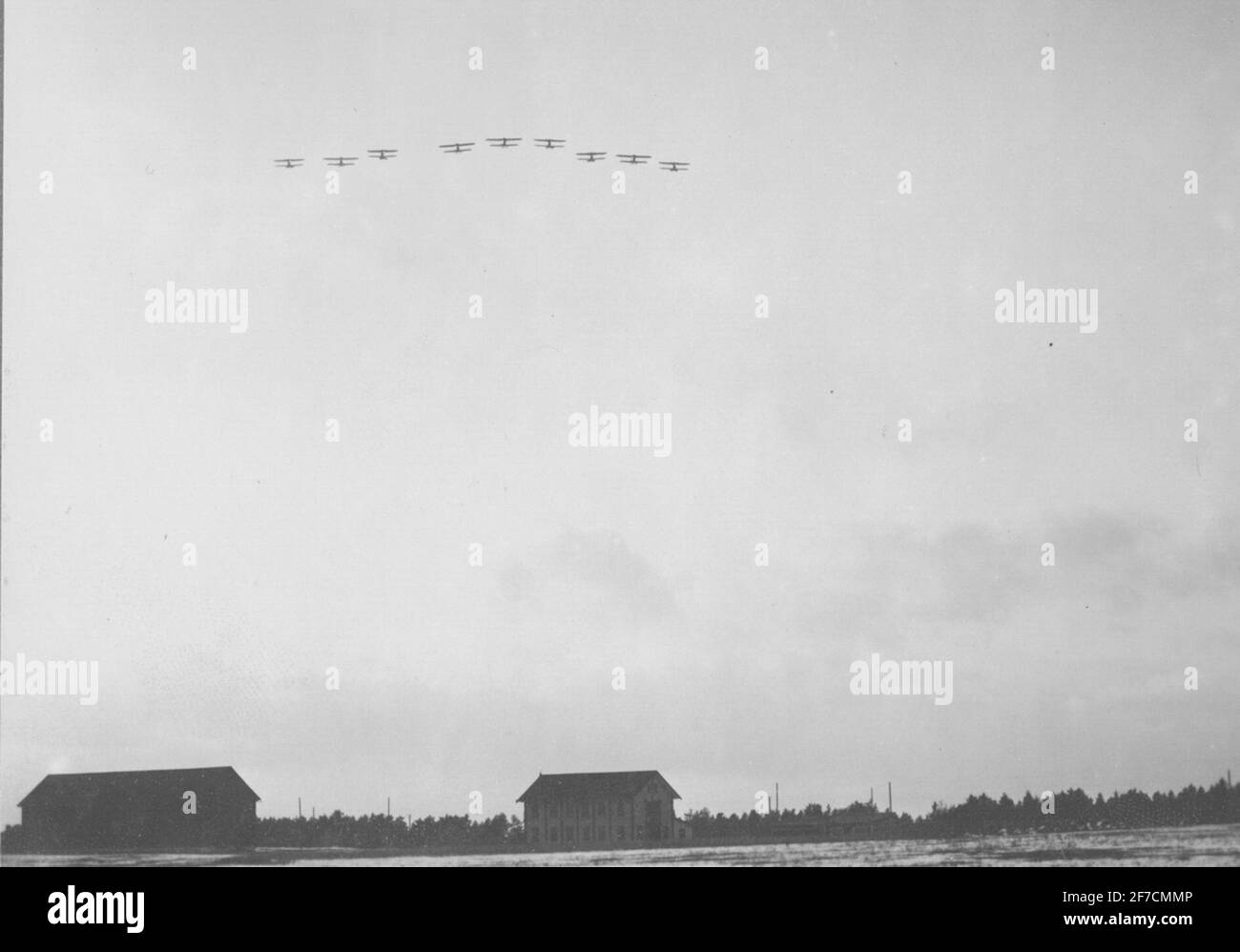 Nine military propeller aircraft flying in formation flight over