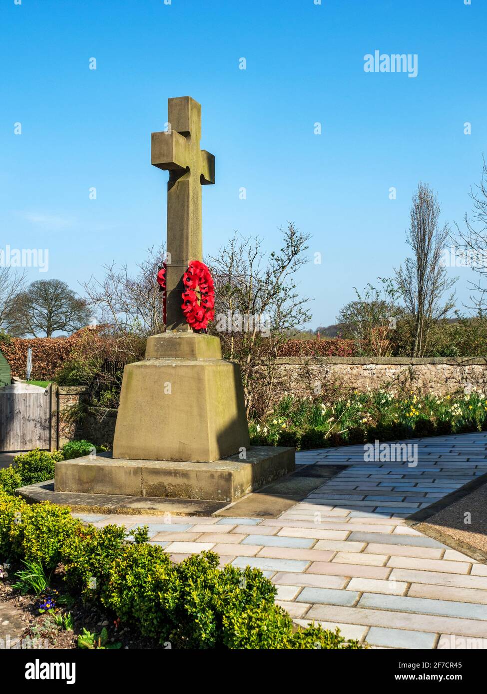 Cross type war memorial on a tapered plinth at St Batholomews Church in Arkendale near Knaresborough North Yorkshire England Stock Photo