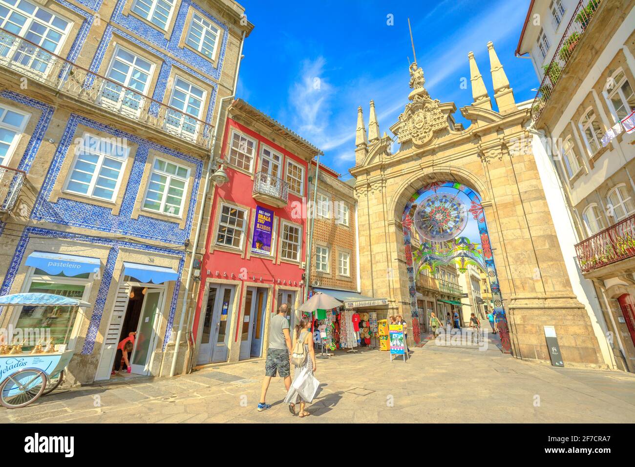 Braga, Portugal - August 12, 2017: people walking through the Arco da Porta Nova, looking east along Rua Dom Diogo de Sousa. Arch of the New Gate in Stock Photo