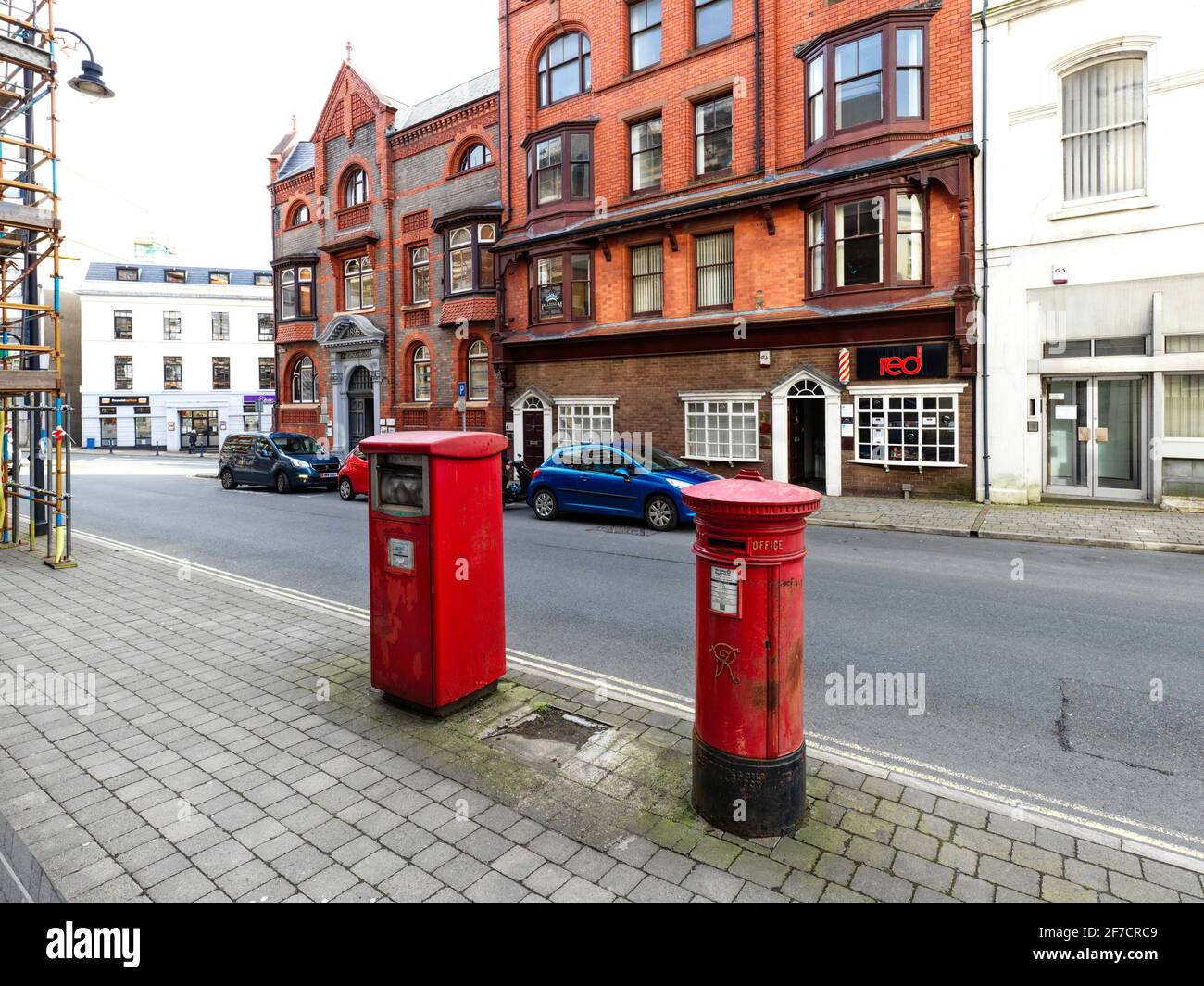 A Victorian pillar box next to a pre franked mail box in Athol Street, Douglas, Isle of Man Stock Photo