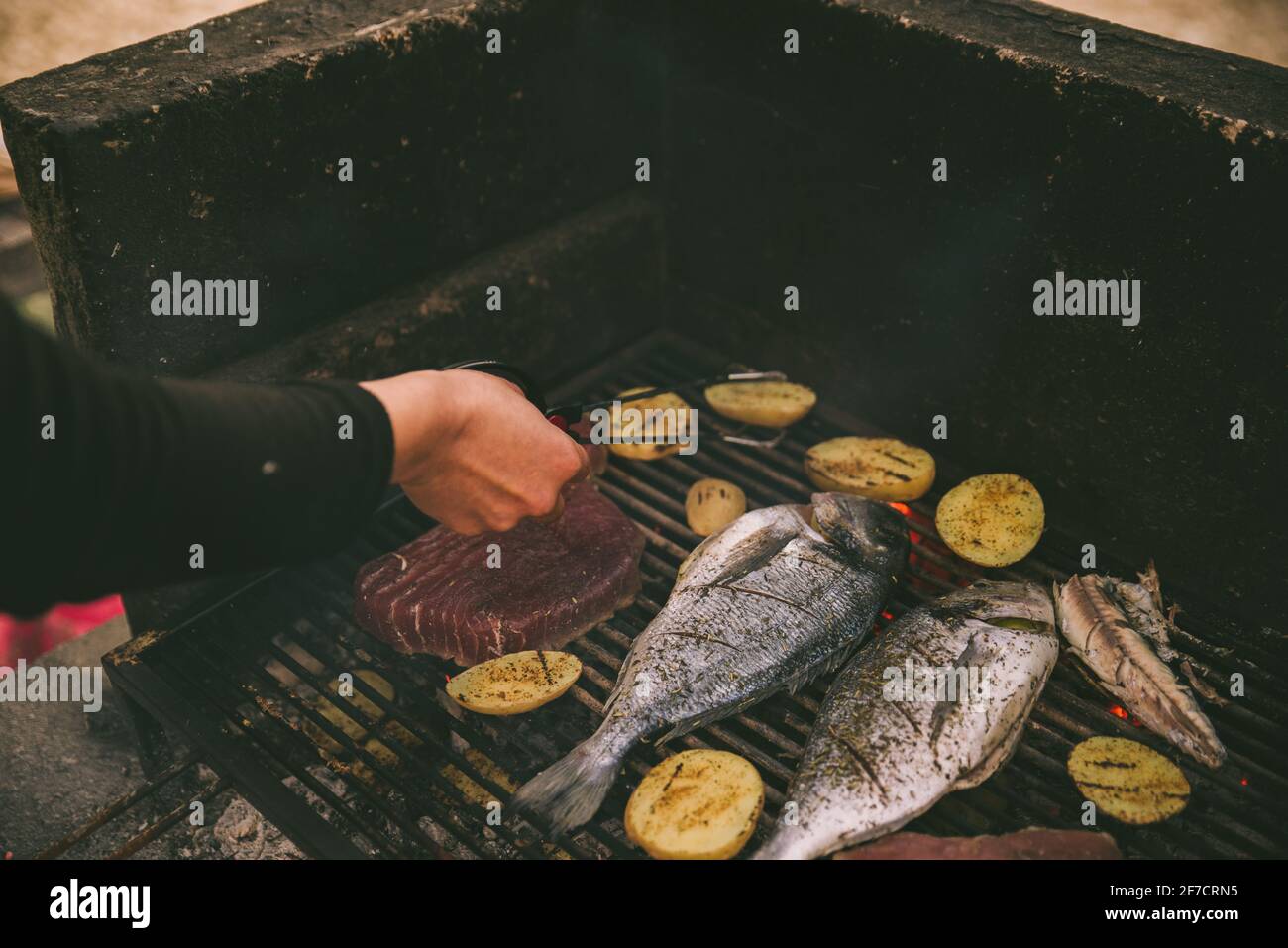 cooking fish and potatoes on grill outdoors Stock Photo - Alamy