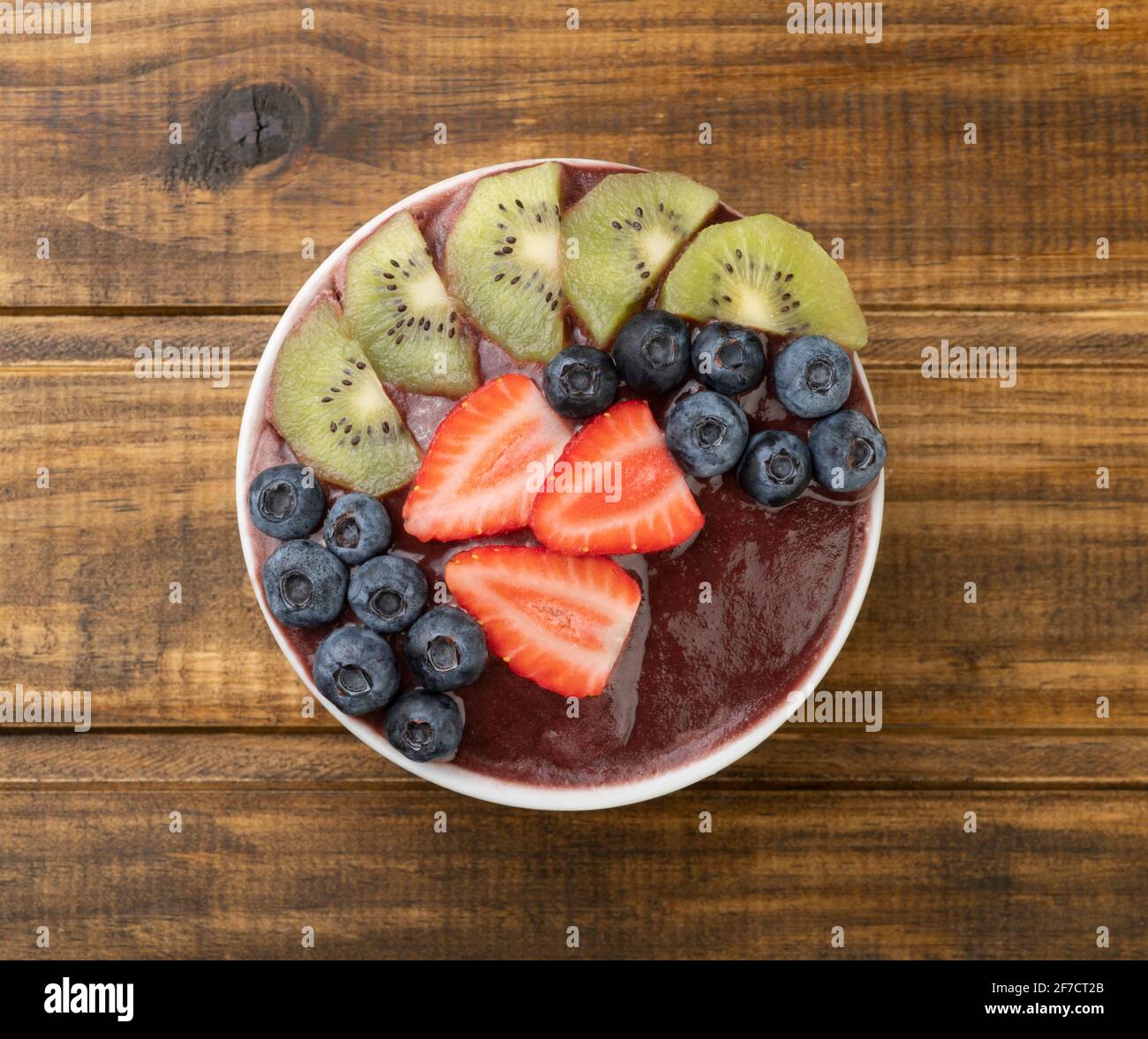 Brazilian typical acai bowl with kiwi, blueberry and strawberry over ...
