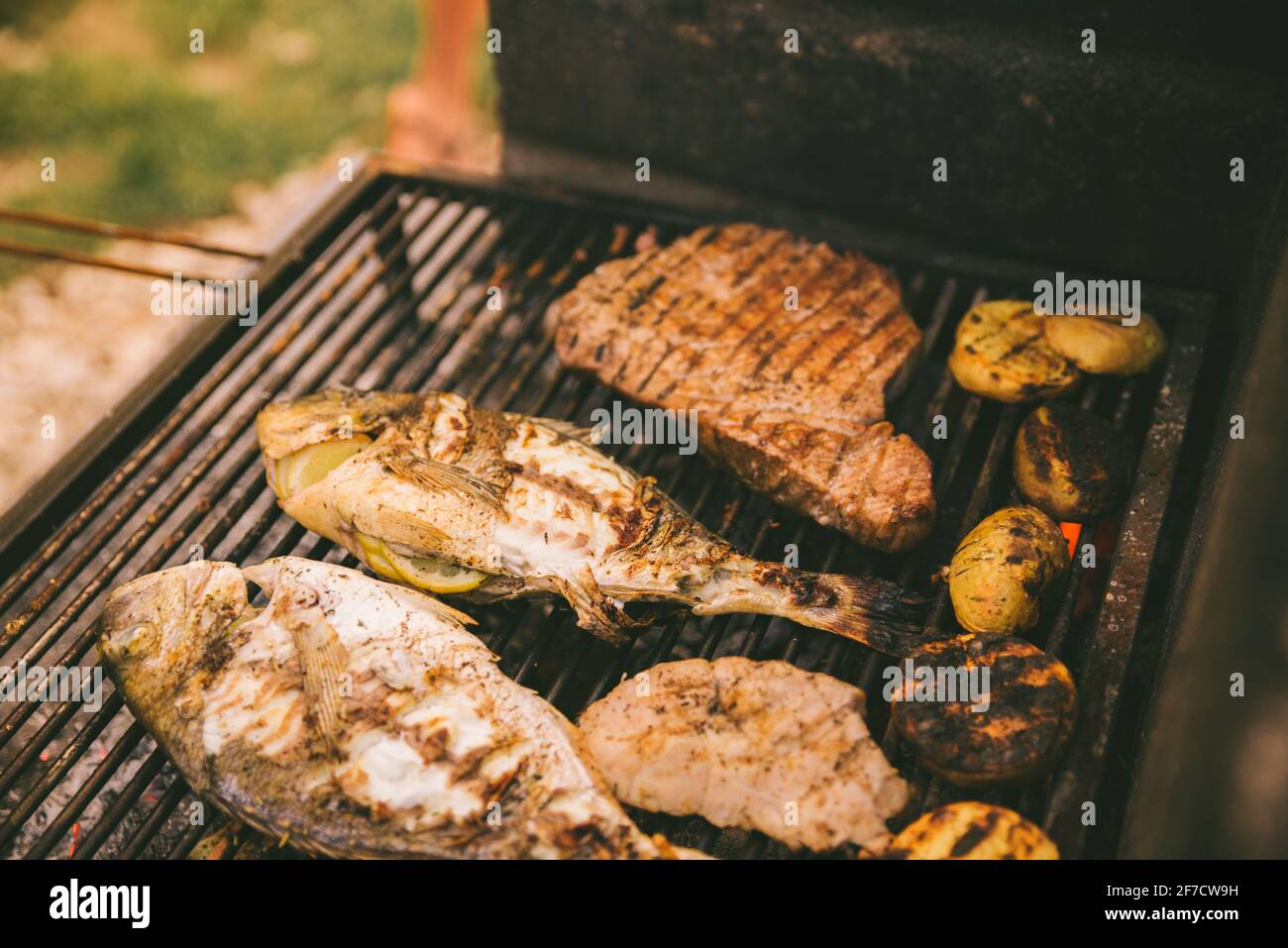 cooking fish and potatoes on grill outdoors Stock Photo - Alamy