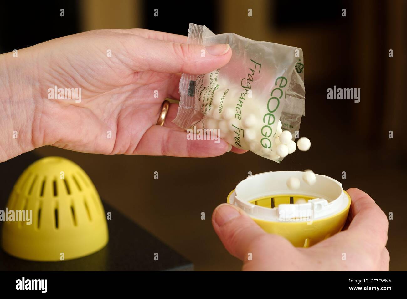 A woman refilling an ecoegg laundry egg with replacement mineral pellets. The ecoegg is an environmentally friendly laundry detergent replacement Stock Photo