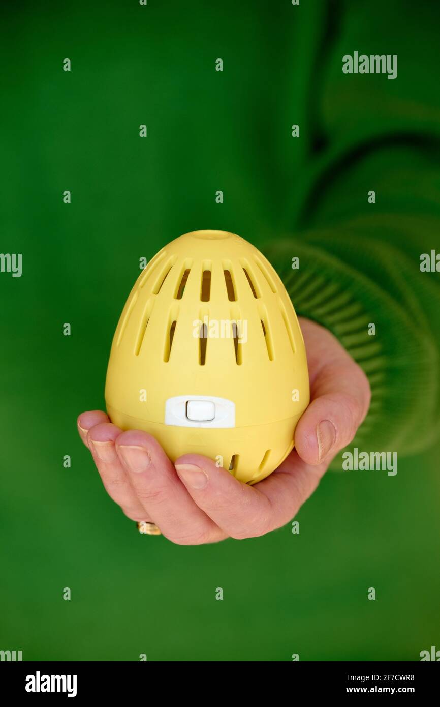 A woman holding an ecoegg laundry egg in her hand. The ecoegg is an environmentally friendly detergent replacement for washing fabrics Stock Photo