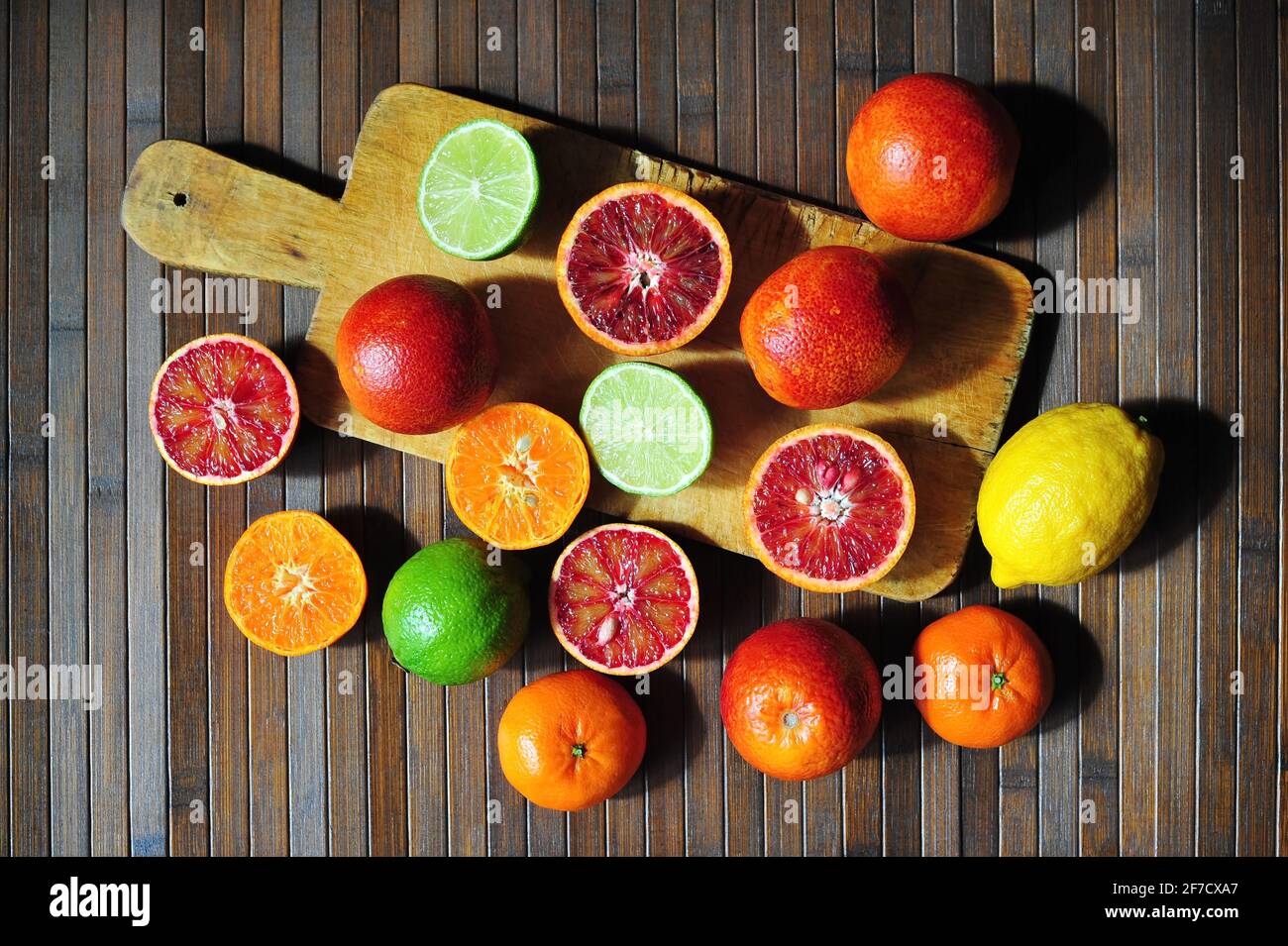 Red sicilian oranges, lime, lemon and mandarine tangerine on cutting board wooden background Stock Photo