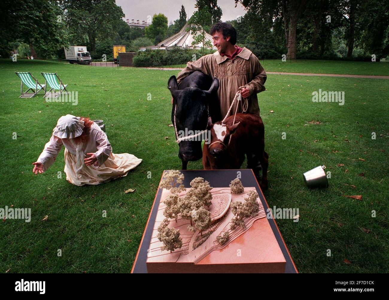 ST JAMES'S PARK  RECEPTIONIST LEE CULLEN JULY 1998AKA THE MILKMAID IS SENT FLYING WITH A WELL AIMED KICK FROM POPPY THE COW, AT A PHOTO CALL TO ANNOUNCE DETAILS OF AN INNOVATIVE NEW RESTURANT IN ST JAMES'S PARK  TO REPLACE THE OLD ONE SEEN IN THE BACKGROUND OF THE PICTURE Stock Photo