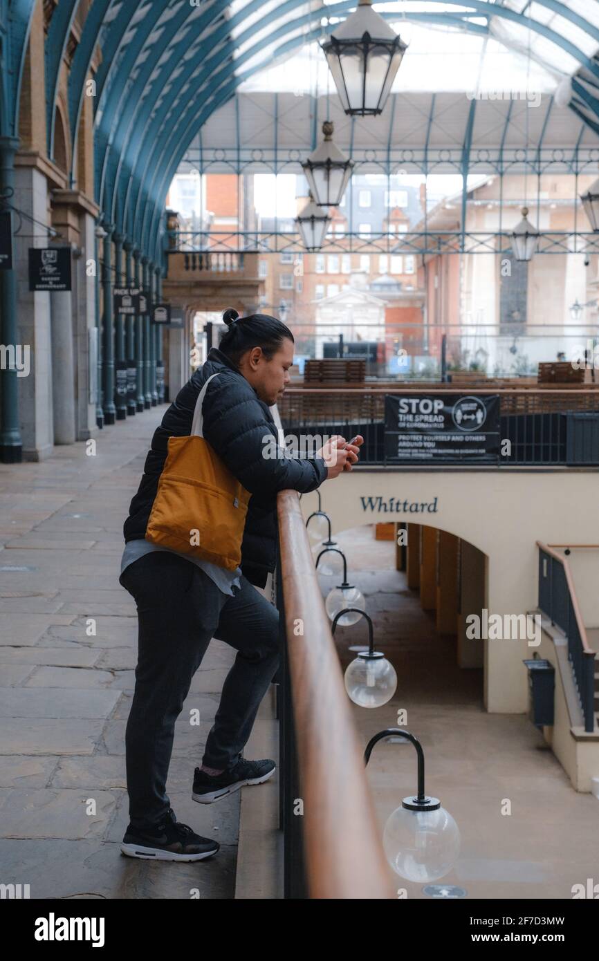London, UK - April 2021 :  A person stands in Covent Garden Market  during the third national lockdown Stock Photo