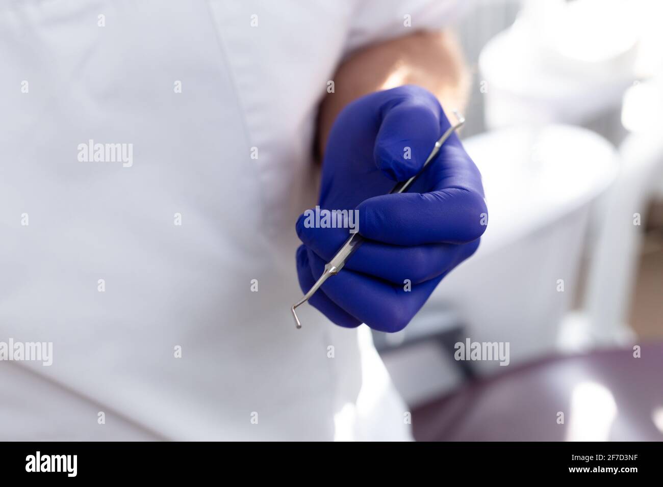Male hands in blue medical gloves hold a dental instrument Stock Photo ...