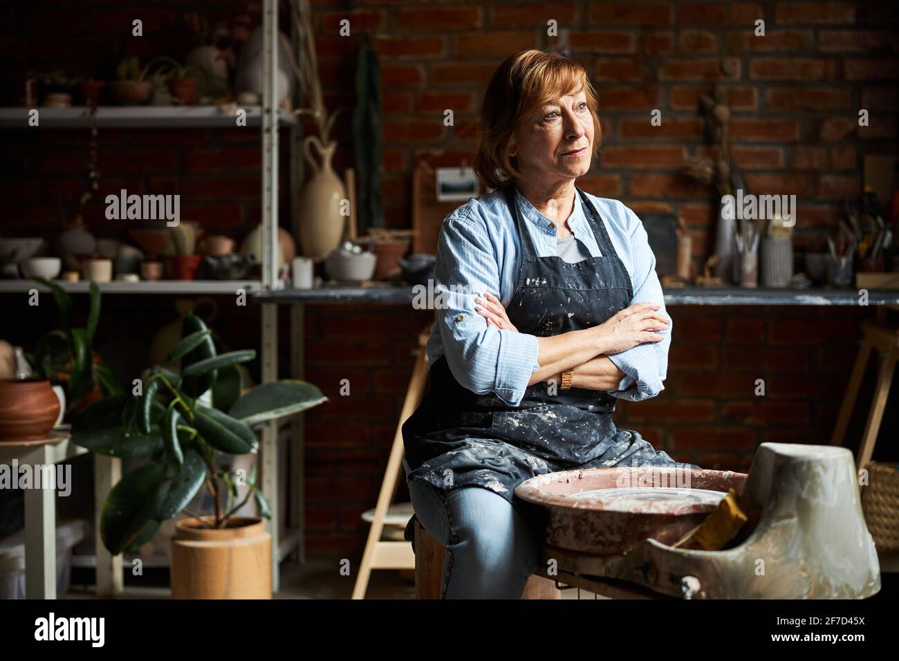 Charming elderly woman working in pottery workshop Stock Photo