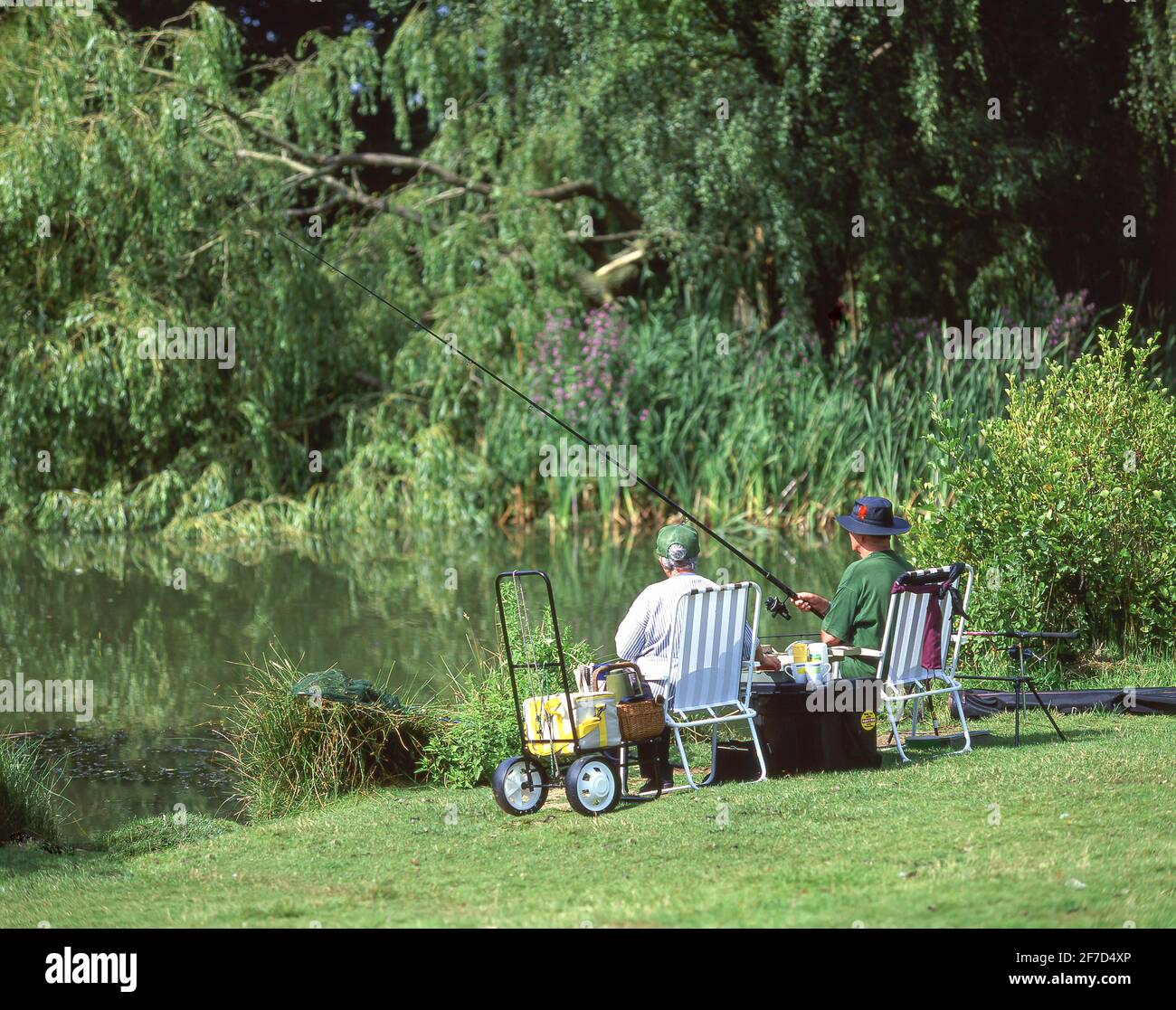 Older couple fishing in small fresh water lake, Stanwell Moor, Surrey, England, United Kingdom Stock Photo