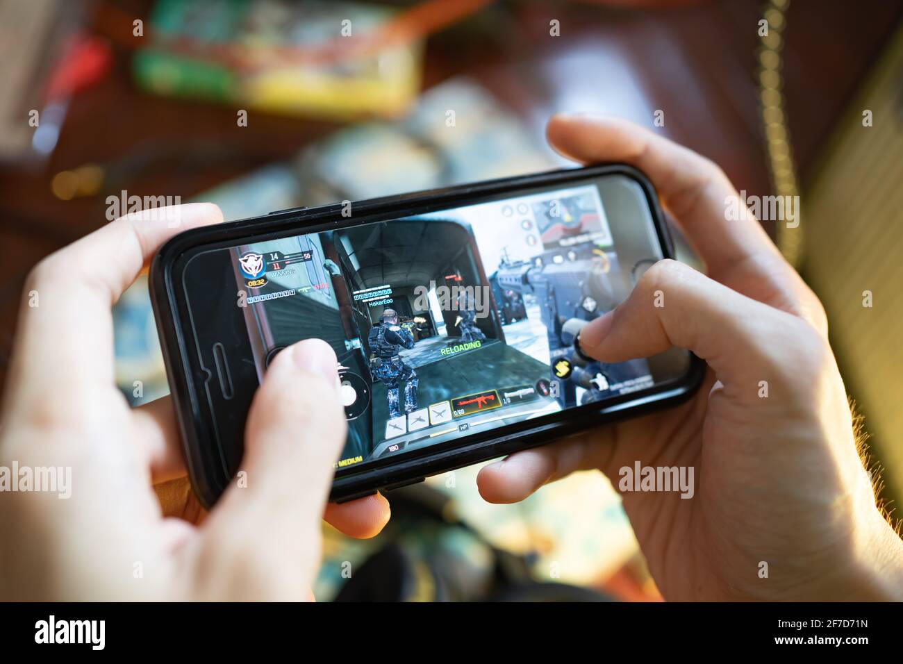 Bangkok, Thailand - April 6, 2021 : A man playing Call of Duty Mobile game on iPhone 7. Stock Photo