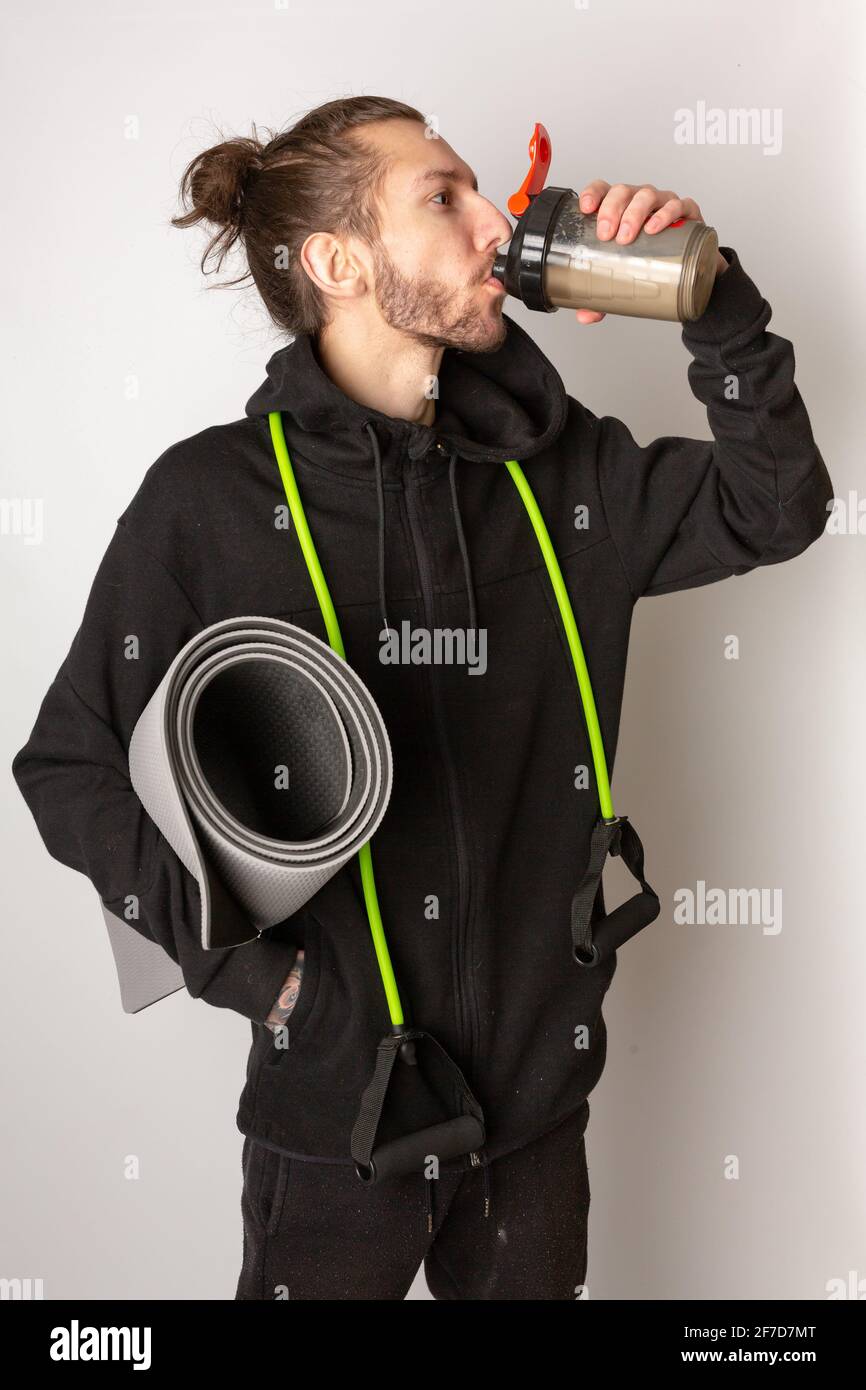 A Young Bearded Man Drinking A Protein Shake After Working Out a-young-bearded-man-drinking-a-protein-shake-after-working-out