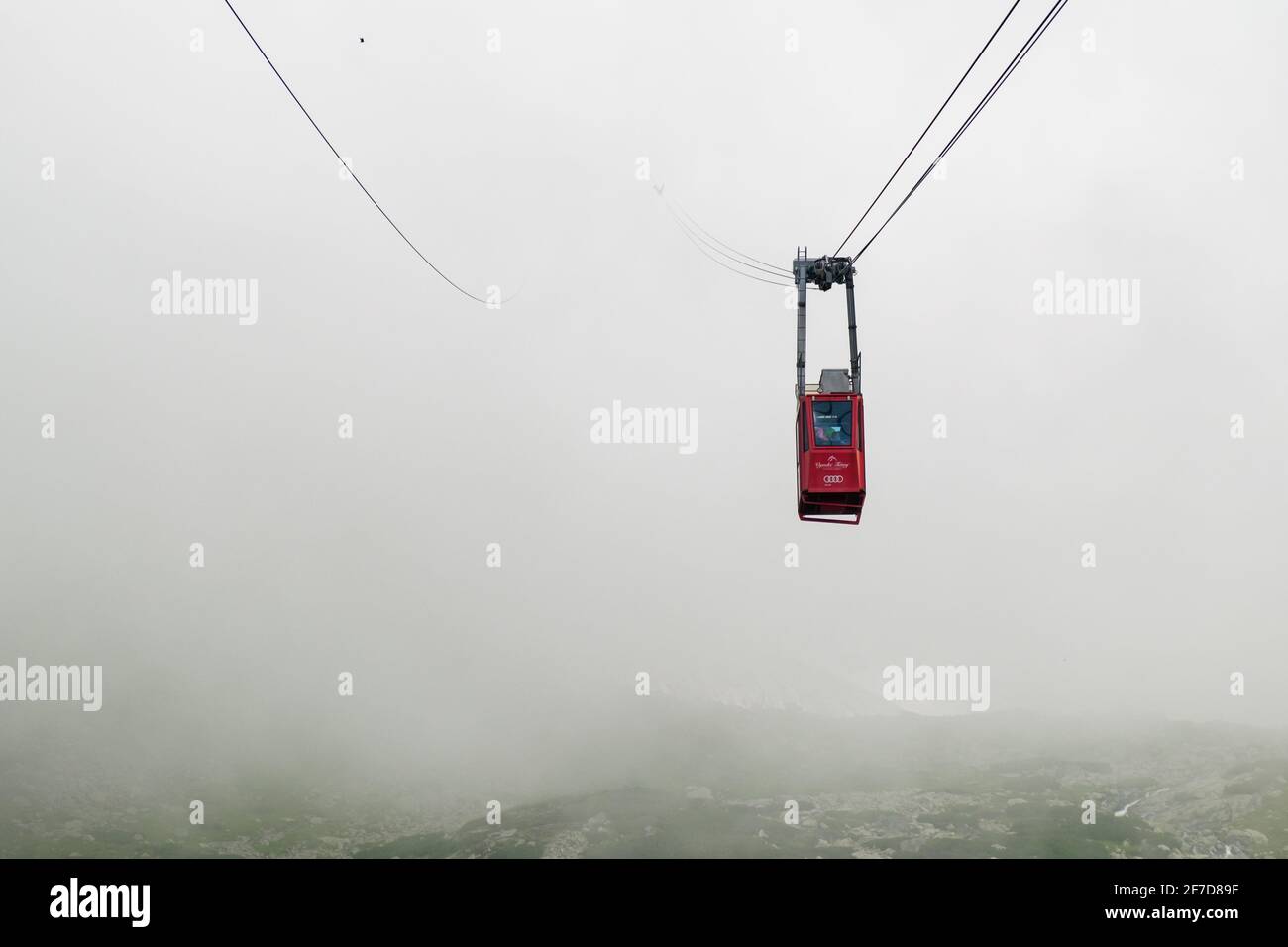 Red funicular or red suspension cable car to Lomnicky peak in fog or clouds, September 2020, High Tatry, Slovakia Stock Photo
